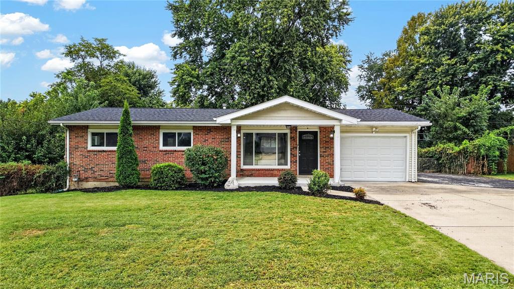 Located in the heart of St. Charles and award-winning Francis Howell School District, this brick ranch keeps daily living on one level and then adds something almost no comparable home nearby offers: a finished lower level of about 840 square feet, updated this year with new luxury vinyl flooring. A covered front porch leads into a bright living room, where a wide front picture window brings in natural light and a half wall opens straight into the kitchen. The kitchen has white shaker cabinets, granite countertops, a stainless steel dishwasher and over-range microwave, under-cabinet lighting, and a window over the sink, with room for a dining table and a rolling island that stays with the home. Luxury vinyl flooring, white six-panel doors, fresh neutral paint, and white vinyl windows with wide trim carry through the main level. All three bedrooms sit together on the main floor with sliding closet doors, and the updated bathroom pairs a white vanity and granite top with a tub and shower combination. Downstairs, the finished space is wide open and ready to be a rec room, home office, gym, or guest space, with a separate unfinished area for laundry and storage. Out back, the level lot runs just under a quarter acre, shaded by mature trees and screened by established hedges, with chain link and wood fencing and a gravel fire pit circle ready for fall evenings. Parking is a real strength here: an attached one-car garage with an opener, a concrete driveway, and a separate side parking pad, so extra cars always have a place to go. The home sits in unincorporated St. Charles County and is served by Harvest Ridge Elementary, Barnwell Middle, and Francis Howell North High. NEW ROOF (2024), UPDATED LOWER LEVEL (2026). Schedule your tour today.