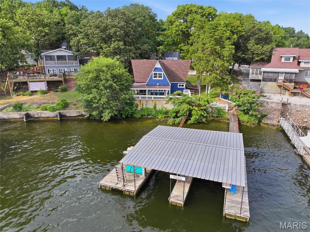 Welcome to your dream lakefront getaway at 35 Knox Rd in Rocky Mount! This turnkey 3-bedroom, 2-bathroom A-frame offers 1,200 sq ft of updated living space on Lake of the Ozarks. Fully remodeled in 2024, step inside to discover luxury vinyl plank flooring, fresh paint, crisp trim, and an expanded kitchen finished with sleek modern appliances. Soak in panoramic main channel views along 100 feet of prime gentle waterfront shoreline. Outdoor living excels with a stamped concrete covered patio, convenient storage shed, and a massive 2-well covered dock featuring electricity, swim platform, and two private slips (10x28 & 10x24). Located in the highly sought-after Mile Marker 4, this prime property includes blacktop access, a concrete seawall, and room to construct a garage. Rare short-term and nightly rental permission makes this property an exceptional income-producing investment or personal sanctuary. Location and convenience is key to full lake fun and profitable rental investment and this property has both! Priced attractively, this rare gem will not last on the market long. Don't miss out on this turnkey paradise—schedule your showing today and start making lake memories!