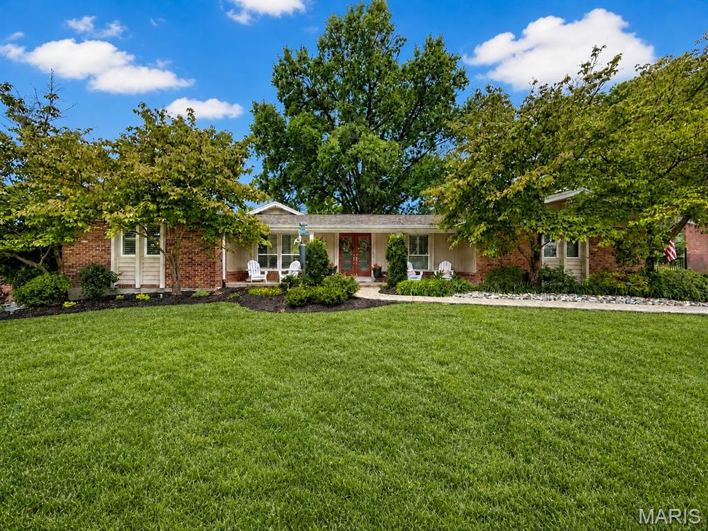 Beautifully renovated ranch situated on a large, level lot in sought-after Green Trails! Rich walnut hardwood floors flow throughout the main level and lead into a spacious open floor plan featuring a private home office, impressive great room with skylight, custom built-ins, and gas fireplace, plus a beautifully appointed kitchen with natural cherry cabinetry and built-in planning desk with glass-front doors. The expansive primary suite addition offers a sitting area, custom his-and-hers walk-in closets, and a luxurious bath with heated floors, walk-in shower, and soaking tub. Three additional bedrooms, two full baths, and convenient main-level laundry complete the first floor. The finished lower level provides even more living space with a massive recreation room, fifth bedroom, full bath, hickory wet bar, abundant storage, and second laundry area. The exterior is fully maintenance-free, featuring four-sided brick construction with aluminum siding on all eaves and soffits. Additional features include a whole house water filtration system, plantation shutters throughout, newer roof with LeafGuard gutters, tankless water heater, high-efficiency furnace, professional landscaping, outdoor lighting, and much more! Conveniently located near schools, restaurants and shops with easy access to major roadways. Schedule your showing today!