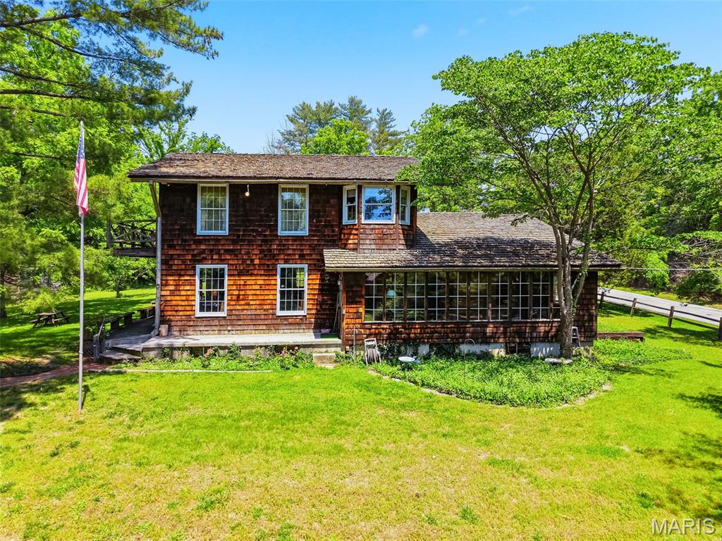 Tucked away near the end of Jacobs Station Road, this unique 11.27+/- acre property in unincorporated St. Charles County offers a rare blend of rustic character, privacy, and future potential. The 2,236+/- sq. ft. 2-story home features 3 bedrooms (and an optional 4th bedroom on the main level), 2 bathrooms, and timeless architectural details including hand-hewed beams, rich wood finishes, and a large wood-burning fireplace that creates a warm, lodge-like atmosphere. Expansive windows and natural materials bring the beauty of the surrounding landscape indoors, while the spacious layout offers endless possibilities for restoration, recreation, or country living.

Outside, a substantial 36x46 barn provides ample space for equipment, hobbies, livestock, storage, or workshop use. The gently rolling acreage offers open ground, mature trees, and peaceful seclusion, making it ideal for a private estate, mini farm, equestrian property, hunting, or weekend retreat. With public water, natural gas, and electric already on site, and public sewer nearby, the property is also well-positioned for future residential development or investment opportunities.

Conveniently located yet quietly secluded, this one-of-a-kind property combines rural charm with accessibility and unlimited potential in a highly desirable St. Charles County setting.