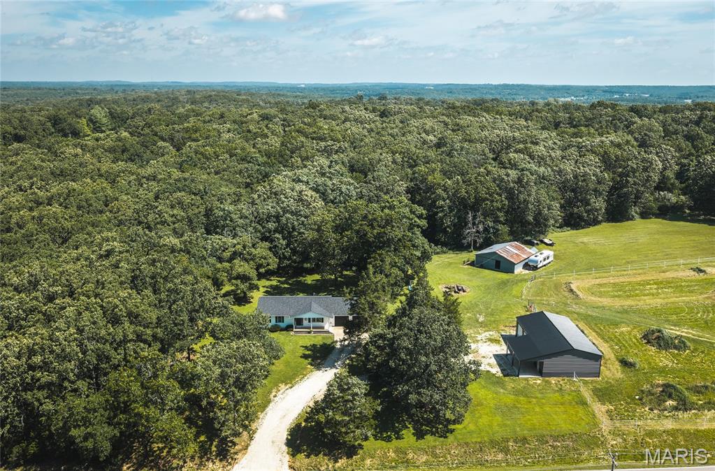 Escape to the peace and privacy of country living with this exceptional 14.58-acre property with a ranch style home with basement, large shop, and horse barn! Whether you're dreaming of a hobby farm, horse property, or simply room to roam, this versatile property offers endless possibilities. Inside the 3 bed, 2 bath home, you'll find a warm and inviting layout featuring durable luxury vinyl plank flooring and a partially finished basement that provides flexible space for a family room, home office, gym, or recreation area. It also has a bonus room that could function as a non-conforming 4th bedroom. Step outside and discover everything you need to embrace the country lifestyle you've been searching for. The recently built 30' x 50' shop has 12-foot side walls and three overhead doors offering an incredible space for equipment, vehicles, hobbies, or a workshop. Complete with water, electric, mini-split HVAC system, and a large covered porch. Horse lovers will appreciate the well-designed 4-stall barn with hay storage, while two pastures provide plenty of room for grazing. An 8' x 10' she-shed is ideal as a creative studio, gardening retreat, or tack room. Enjoy quiet mornings overlooking the small pond or explore the wooded acreage that can be great for hunting. The house has a new roof and garage doors installed in 2025, and also has an outdoor wood furnace that can help keep your utility bills lower throughout the colder months. With the back pasture offering the potential for a future homesite, this property also provides an exciting opportunity for expansion or multi-generational living. If you've been searching for the perfect blend of country charm, functional amenities, mix of pasture and woods, this one is a must-see. Schedule your private showing today and experience everything this incredible property has to offer!