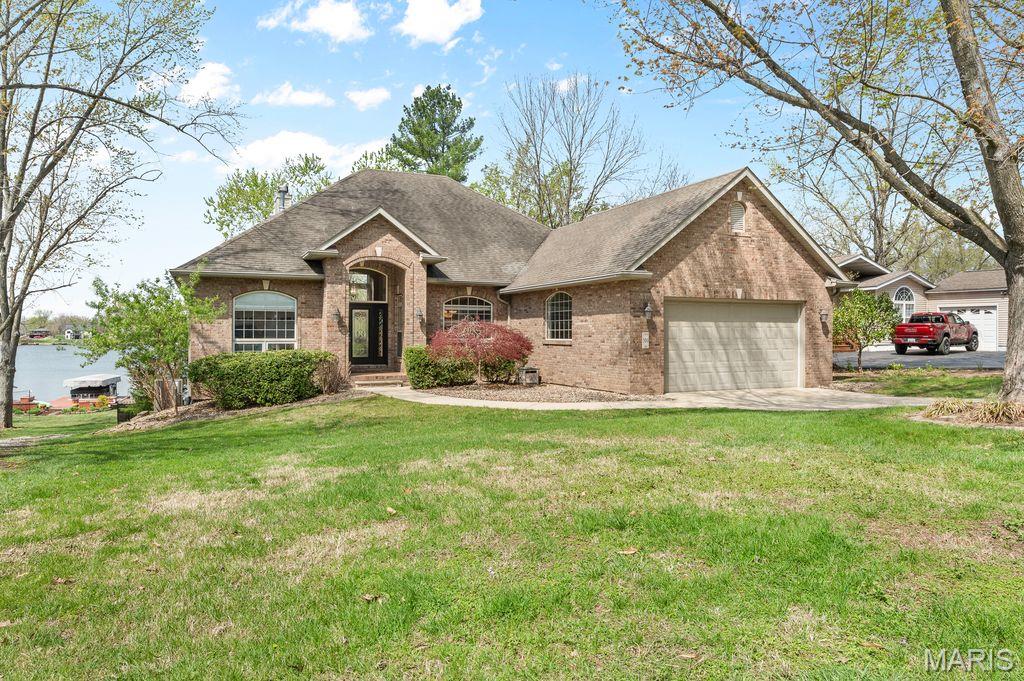 Welcome to this magnificent lakefront custom built 4-bedroom, 4-bathroom ranch home that spans 3,330 square feet of meticulously designed living space. From the moment you arrive, you'll be captivated by the breathtaking views from the great room with one of two fireplaces and an expansive wall of windows offering an elegant yet comfortable ambiance.  This inviting open floor plan features a brilliant split-bedroom design. The great room and kitchen boast expansive ceilings and every room has transom windows filling the space with natural light. The eat in kitchen with hardwood floors is equipped with stainless steel appliances, peninsula with an additional seating area , ample counter space and located next to the formal dining room. The laundry room is located on the main floor for your convenience.  The allure of this home continues into the walk-out lower level with a spacious family room that boasts a second cozy fireplace—a perfect spot for gatherings or relaxation. Here, you'll also find the fourth bedroom, a hall bath, a versatile flex room with a walk-in closet and a private en suite full bath ideal for guests, home office or workout area.  The outdoor amenities of this dazzling property are equally impressive. The covered boat dock with two electric boat lifts makes lake access a breeze. Whether you're keen on water sports or just want to enjoy a sunset cruise, this feature promises endless summer fun. The fenced yard provides a secure space for pets or children to play.  The expansive deck and lower patio are perfect for barbecues and entertaining.   Enjoy unrivaled views of the spectacular 4th of July fireworks right from your backyard. This home offers more than just luxury; it offers a lifestyle. Located in the highly sought-after Holiday Shores neighborhood, you'll benefit from easy in and out access.  Living in Holiday Shores isn’t just about owning a home; it’s about enjoying a vibrant lifestyle with incredible community amenities. You will love the proximity to the beaches, perfect for sunbathing, swimming, or simply unwinding by the water. The clubhouse serves as a hub of social activity with tennis/pickleball courts, restaurant coming soon and beach access, while the marina offers convenient access for boating enthusiasts. If you love to fish, this lake is perfect and you have the option to join the fishing tournaments.  Children and parents alike will appreciate the well-maintained community playgrounds adding fun and convenience right in your neighborhood. Don’t miss out on the chance to own this remarkable property in a lake community that has it all. Schedule your private showing today and experience firsthand the unparalleled lifestyle waiting for you at Holiday Shores! Visit www.holidayshores.us for information including covenants/bylaws. Yearly $810 HOA plus a one time initiation fee for new members. New roof May 2026.  Buyers to verify all information prior to making an offer.