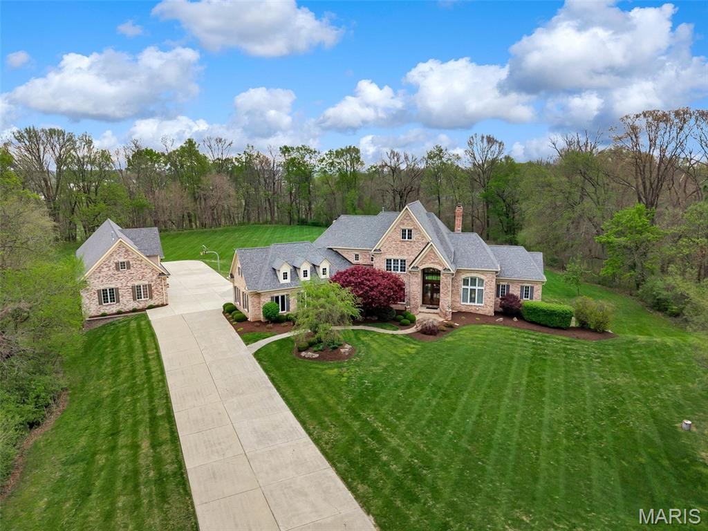 Tucked away at the end of a private cul-de-sac and set on six breathtaking acres, this extraordinary estate delivers a level of privacy and seclusion that is nearly impossible to find in Chesterfield. Surrounded by mature landscape and set far off the road, the setting feels like your own private retreat.

The remarkable grounds offer endless possibilities—whether envisioning a resort-style pool, equestrian estate, tennis court, or ultimate outdoor sanctuary.

A true standout, the expansive 6-car detached garage is a dream for the car enthusiast, with the versatility to be converted into a guest residence, carriage house, or barn. A 3-car attached garage adds everyday convenience.

The home’s stunning exterior makes a lasting first impression, while inside, a light-filled, thoughtfully designed floor plan blends elegance with livability. The spacious kitchen is ideal for both entertaining and daily living.

The main-floor primary suite offers a private escape, complete with a luxurious bath and generous his-and-hers closets, duel showers and heated floors. Upstairs, three large bedrooms are complemented by an expansive bonus living area—perfect for relaxing or hosting.

A refined private office and inviting living spaces complete this exceptional residence—offering a rare opportunity to own a secluded, estate-style property with limitless potential.