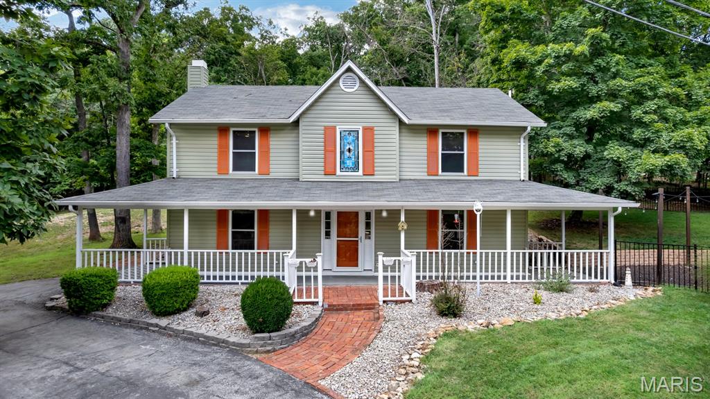 Have you been looking for an updated home under $300k in Marthasville? Here’s your chance to live in a gated lake community, across the street from the lake, and a short distance from the Community Center, Lakeside Grill, Sandy Beach, and Pool!  Welcome to this beautifully updated 3-bedroom, 2.5-bath, 2-story home in Lake Sherwood, MO! Located across from Peninsula Park, this home offers convenience, charm, and seasonal lake views. Relax on the spacious covered front porch, perfect for decorating, entertaining, or enjoying the outdoors. Inside, you will find thoughtful updates throughout: luxury vinyl plank flooring, light fixtures,  showerheads, and stainless steel appliances. Additional improvements include new siding, shutters, fencing, shed, retaining wall, hot water heater, and a remote outdoor lighting system. The roof, gutters and leaf guard system is only 7 years old, and a radon mitigation system is already in place. The partially fenced yard is perfect for children, pets, or a garden with plenty of space to enjoy outdoor living safely and comfortably.  Choice Ultimate Home Warranty will be transferred to the new owner and is in place until Aug 2028. The vacant lot next door (417 Marina Drive MLS #26048550) is also available for sale.  Lake Sherwood is a serene, gated community known for its welcoming neighborhood, scenic lake views, and abundance of recreational amenities. Residents enjoy access to the clubhouse, pool, beach, restaurant, and seasonal lake activities, all just steps from this home. This move-in-ready home blends charm, updates, and location all in one!  Keep in mind this is a gated community and you must have a Realtor with you to view this property. We invite you to come live the lake life at Lake Sherwood MO!
