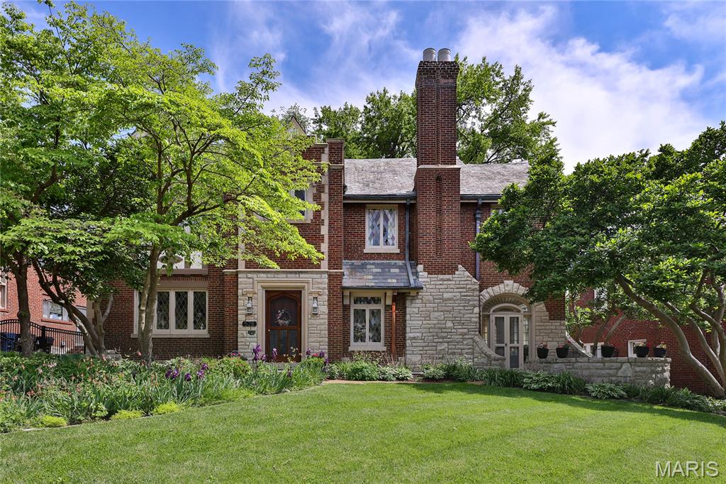 A beautiful, impeccably maintained, University Hills home. Stained glass windows grace the entire front facade. Slate roof has been regularly maintained. You’ll enjoy sunlit rooms, arched openings, & original architectural details. The lovely, sunken Living Room has a decorative Fireplace, stained glass windows, & leaded glass French doors to the private stone Patio. Living Room opens to comfortable Sunroom. Dining Room has more stained glass & ample space for large furniture & gatherings. The Kitchen was thoughtfully & charmingly remodeled. It includes instant hot water tap, pot racks above the range, 2 ovens, abundant cabinets & drawers, large eat-in area, & Laundry Area behind a sliding, frosted glass door. Back staircase to 2nd Floor starts in the Kitchen. There’s easy flow throughout the First Floor. A charming Powder Room, & a peaceful Three Season Room, surrounded by lush landscaping, complete the 1st Floor. (3 Season Room isn’t served by HVAC so isn’t included in sq footage; a mini-split could solve this.) The oversized landing between 1st & 2nd Floors serves as charming Sitting Room with large stained glass window. 2nd Floor has 4 Bedrooms, 2 Full Baths. Primary Bedroom has stained glass windows, a Closet/ Dressing Room, & original En Suite Bathroom with stunning tile, columns, soaking tub, & separate shower. 3 additional Bedrooms & a  remodeled Hall Bath complete the 2nd Floor. The 3rd Floor has 2 Bedrooms, a remodeled Hall Bath, & very large Flex Room. Flex Room, with built-in cabinetry & shelves, has many possible uses. The walk-out Basement has a Laundry Area & much unused space. Yards have mature trees & shrubs, lush perennials, walled stone patio & stone sidewalk.