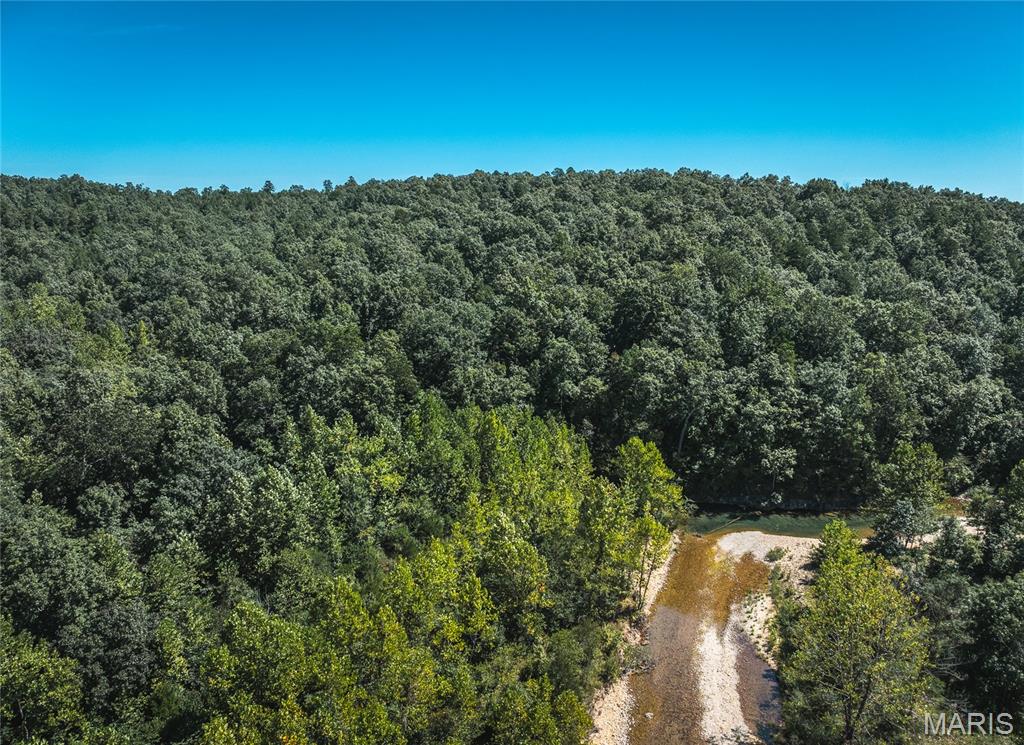 297 acres in the Ozark Mountain range offering outstanding hunting, recreation, and investment opportunity. This diverse property features a year-round creek, five wildlife ponds, five food plots, and an established trail system for easy access. Abundant wildlife includes whitetail deer, turkey, quail, bobcat, and black bear. Managed under USDA/MDC timber programs, the land holds both natural beauty and marketable timber value.
Improvements include a 30x40 pole barn with concrete floor, garage door, and entry door; a 50’ two-bedroom, one-bath living trailer with electricity; and a 40’ Conair unit with side door for storage. The property also includes chestnut trees, pecan trees, and wildflowers that add seasonal beauty.
Easily accessed from a paved blacktop road, this tract is ideal for hunting, fishing, ATV riding, hiking, camping, or a private family retreat. A rare chance to own nearly 300 acres in the Southeast Missouri Ozarks with live water and improvements already in place.