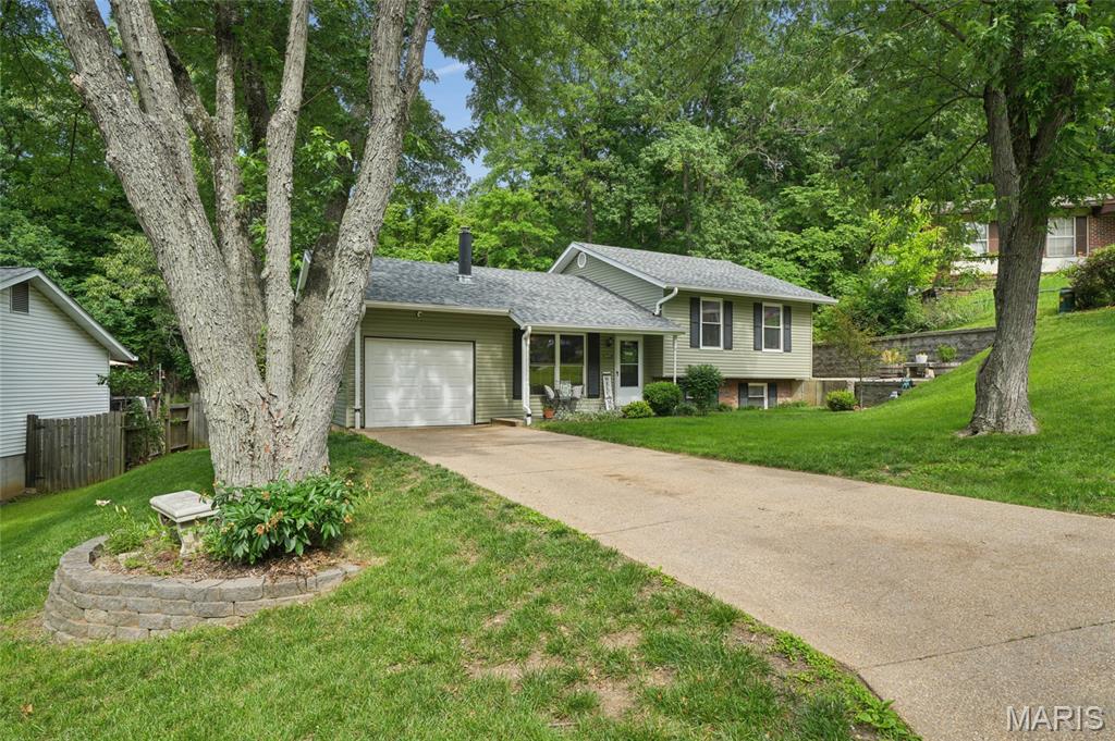 Loved 4 bedroom Multi-level home in a great location! This home sits on a lot at the edge of the cul-de-sac. The front yard has lots of shade and a nice covered front porch.  Once inside you will find a recently updated kitchen with new cabinetry and quartz counter tops as well as a stone flooring., The living room offer wood burning stove/fireplace that keeps the home nice and toasty during the winter months. Upstairs are three bedrooms and updated full bathroom. The lower level has a walk out basement door, a bedroom and a half bath/mud room. Lots of storage. Class 4 impact roof, May 2026, Vinyl Siding 2021, New Gutters 2023, & New Deck 2021.
Home owner says; We love that the home backs to woods, it's very private and peaceful in the backyard. The perennials planted in the yard, make it low maintenance, and beautiful. We like that the house has an open feel to it, even if you are upstairs, you feel very close to everyone downstairs. The kitchen countertops are beautiful, with plenty of space and We love the large window in the kitchen that lets beautiful light in. The stone tile floor in the kitchen is very sturdy and elevates the space. We love making fires in the cozy wood burning stove in the winter, and grabbing a book to read off of the custom-built bookshelf. Feels like a cozy cottage.