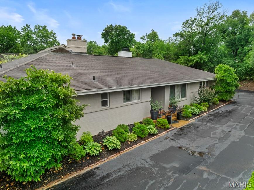Tucked away on a quiet lane in the heart of Ladue, this beautifully updated ranch offers effortless living in an exceptional location. Thoughtfully renovated with timeless style and quality finishes, the home is filled with natural light. The living room features a gas fireplace and French doors that open to a private aggregate patio, extending the living space outdoors. Oak hardwood floors run throughout the main level. The main level also includes a spacious dining room, a laundry room, and a powder room. At the center of the home, the beautifully renovated kitchen showcases marble and soapstone countertops, abundant custom cabinetry, and a gas fireplace. The primary suite serves as a relaxing retreat with a generous walk-in closet, additional storage, and a luxurious bath featuring dual vanities, a soaking tub, and a glass-enclosed shower. Two additional bedrooms share an updated full bath. The finished lower level offers flexible living space, including a large recreation room, a full bath, a cedar closet, and ample storage. An attached two-car garage is included. Walk to Ladue's shops, restaurants, parks, and award-winning schools.