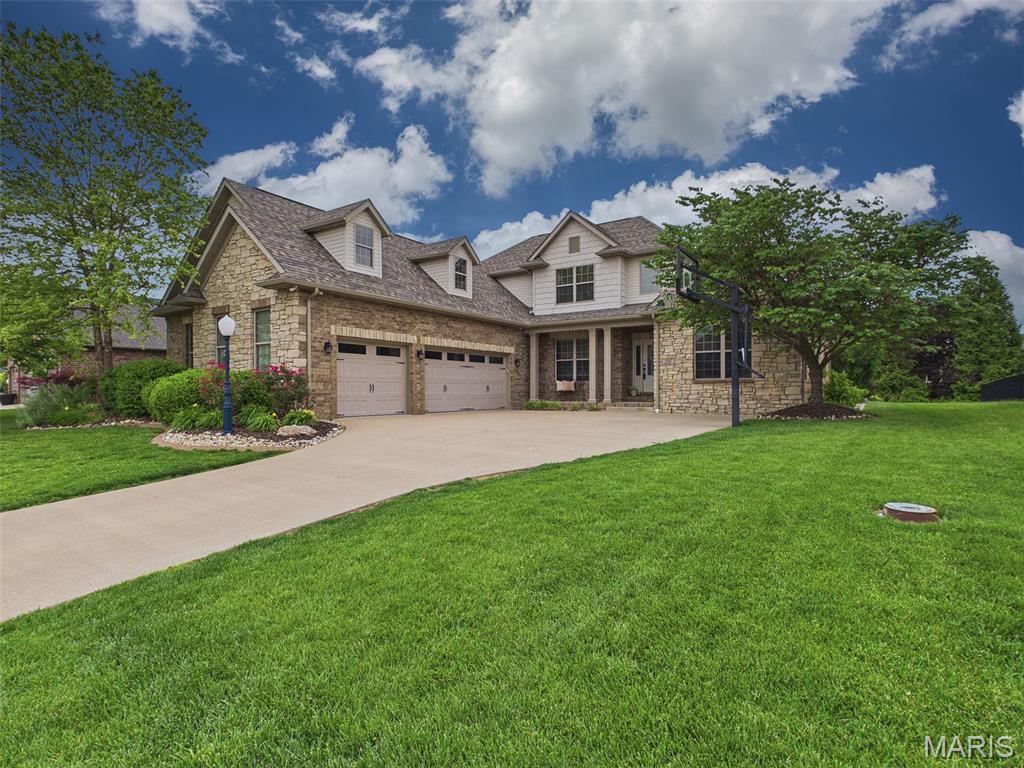 Custom Built 1.5-story home offering 5 bedrooms, 4 bathrooms, and an exceptional layout designed for both everyday living and entertaining. An inviting two-story entry foyer opens to a stunning great room featuring a floor-to-ceiling stone fireplace. The spacious kitchen showcases warm white custom cabinetry, a gas cooktop, wall oven, oversized center island, breakfast bar, planning desk, and adjoining hearth room creating the perfect gathering space. Enjoy family meals in the formal dining room just off the kitchen. The breakfast nook conveniently walks out to your backyard paradise with an incredible covered patio. Enjoy resort-style outdoor living with a saltwater pool, hot tub, outdoor fireplace, and a custom wood-fired pizza oven imported from Portugal. This private outdoor retreat is truly built for entertaining family and friends.
The main-floor primary suite offers a luxurious spa-like bath featuring a walk-in shower and oversized walk-in closet. Upstairs you’ll find two spacious bedrooms connected by a Jack-and-Jill bath. The finished walk-out lower level includes two additional bedrooms, full bath, office/bonus room, large rec room, and wet bar adding to your entertainment space. Additional highlights include a brand new roof, irrigation system, fenced yard, and oversized three-car garage with epoxy flooring, all situated on a quiet cul-de-sac street.