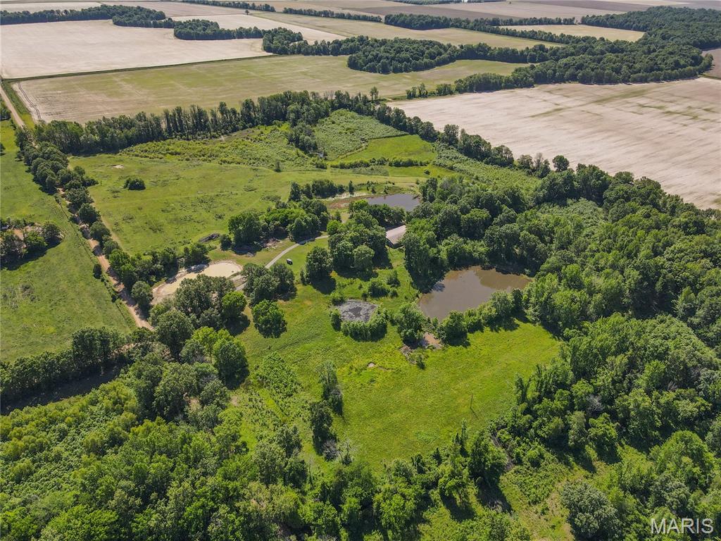 ESCAPE to peaceful country living on 40 private acres featuring 2 stocked ponds and room to roam!  Priced at an incredible $125,000 below appraised value, this property comes with built in equity!! This spacious new build offers over 2,400 sq. ft. of living space!  Mostly finished, this home has a huge open living area, with many custom touches such as a massive walk in shower in with dual rain shower heads, a large kitchen with custom island, radiant floor heat for year-round comfort, but also has just enough space to add your finishing touches to make it your own. The oversized 2-car garage includes a game room and full bath, perfect for entertaining, hobbies, or guest space. Step outside to the massive entertainer's porch (960 sq ft) overlooking the beautiful countryside. A rare opportunity to enjoy privacy, recreation, and endless potential!
