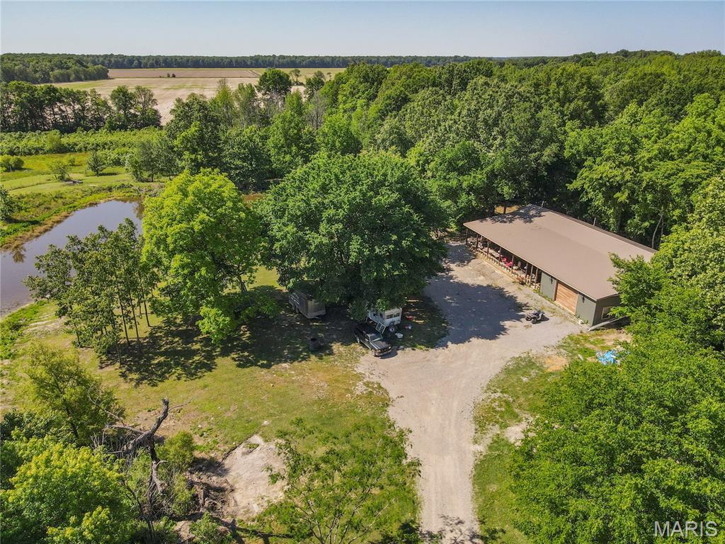 Now priced $50,000 below appraised value, this property comes with built in equity!!  Escape to peaceful country living on 40 private acres featuring 2 stocked ponds and room to roam! This spacious home offers over 2,400 sq. ft. with radiant floor heat for year-round comfort and is ready for your finishing touches to make it your own. The oversized 2-car garage includes a game room and full bath, perfect for entertaining, hobbies, or guest space. Inside, you'll love the huge walk-in shower with dual rain shower heads and the open feel throughout. Step outside to the massive entertainer's porch (960 sq ft) overlooking the beautiful countryside. A rare opportunity to enjoy privacy, recreation, and endless potential all in one property!