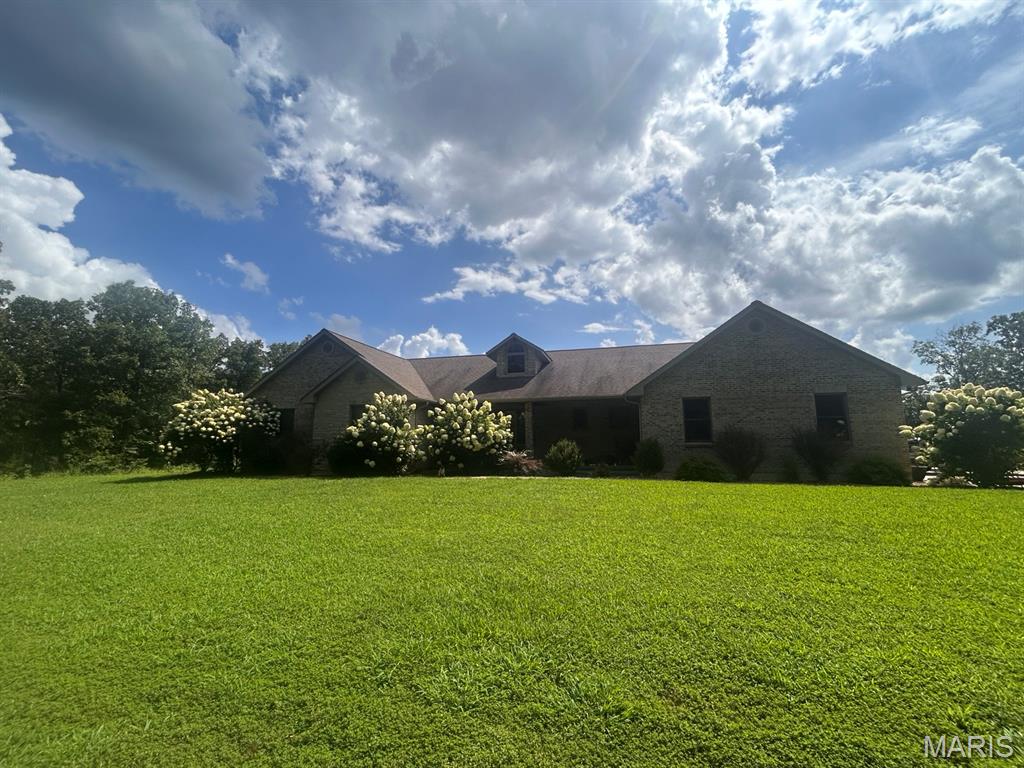 Set on exactly 10 beautiful acres, this impressive custom-built home offers nearly 4,700 square feet of finished living space, exceptional construction quality, and room to live, gather, and entertain on an entirely different scale. Built with a 100% masonry exterior of brick and stone, double-insulated walls and floors, Andersen windows throughout, and geothermal heating and cooling, this is a home where quality extends far beyond what you can see.

Step inside to a light-filled main level showcasing quality finishes, beautiful hardwood flooring, soaring ceilings and an impressive two-story wall of windows. A dramatic hardwood staircase overlooks the open living spaces, while a striking stone fireplace creates a stunning focal point. The spacious kitchen offers granite countertops, abundant cabinetry, stainless appliances, pendant lighting and generous breakfast-bar seating, opening naturally to the dining and living areas. A wonderful egress window-lined sunroom provides yet another place to relax while enjoying views of the surrounding property.

The spacious primary suite offers a private retreat with hardwood flooring, a large walk-in closet and an ensuite bath featuring a jetted soaking tub, separate tiled walk-in shower and generous vanity space. Two additional main-level bedrooms, ample storage and thoughtfully designed living spaces provide the flexibility today’s buyers are looking for.

The main level quality finished walkout lower level is an incredible extension of the home and was made for entertaining. Here you’ll find 2 additional bedrooms, a full Jack & Jill bath, expansive recreation and living areas, an impressive wet bar with extensive cabinetry and bar seating, and an additional bonus room offering endless possibilities for a home office, gaming room, or hobby space. Multiple egress windows throughout the lower-level living areas and the walkout design bring in abundant natural light and create a bright, welcoming atmosphere.

Outside, approximately 10 acres provide the space and privacy so many buyers are searching for. Enjoy the above-ground pool and outdoor gathering areas, wooded surroundings and plenty of room to simply enjoy country living.

Additional features include central vacuum, private well, mudroom with dog-wash station, generous storage and an oversized attached garage with room for 2 vehicles, equipment and recreational toys.

From its all-brick-and-stone masonry exterior and quality construction to its expansive finished living space, incredible lower-level entertaining areas and peaceful acreage setting, this property offers a combination of space, craftsmanship, privacy and versatility that is difficult to duplicate. This is one you truly need to experience in person to appreciate everything it has to offer! Schedule your tour today!