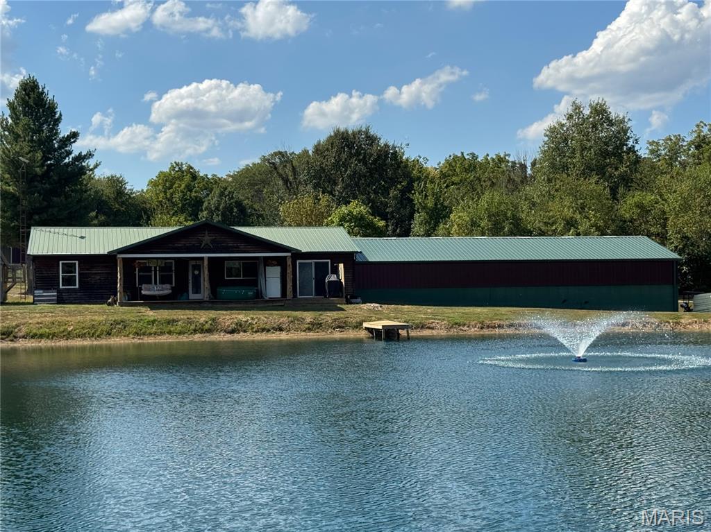 Country living with a setting that’s hard to beat! Situated on nearly 7 acres in a peaceful rural subdivision, this approximately 1,500 sq. ft. home overlooks a beautiful 1-acre fully stocked pond, complete with a fountain and dock—perfect for fishing, relaxing, or simply enjoying the view.

The home offers a warm, rustic feel with a spacious covered porch that’s made for unwinding and taking in the peaceful surroundings. Inside, you’ll find comfortable living spaces, a functional kitchen with ample cabinetry, and plenty of natural light.

But the real showstopper for anyone needing workspace or storage is the impressive 32’ x 62’ attached shop with 13’ ceilings. With room for vehicles, equipment, recreational toys, projects and more, the possibilities are outstanding. A detached garage and carport provide even more parking and storage options.

Outside, the acreage offers plenty of room to spread out, while the stocked pond creates your own private recreational retreat right at home. Also includes space for a 30 amp plug and sewer drop for any camping visitors.

Nearly 7 acres, a stocked pond, dock, huge shop, detached garage, carport and a peaceful country setting—all in one property. Whether you’re looking for room for your hobbies, a serious workshop, or simply a place to enjoy a little more space and privacy, this property has so much to offer