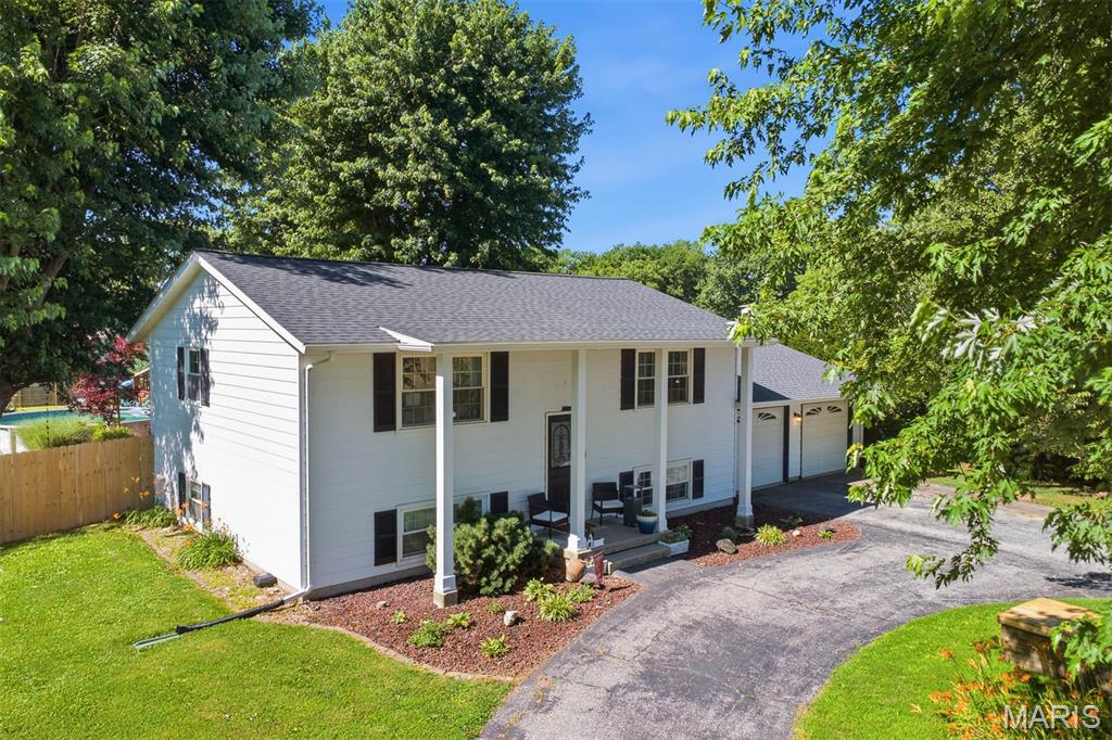 A Little Bit Country and a Lot of Great Features! Picture yourself enjoying the expansive back yard patio that leads to the sundeck and refreshing above ground pool this summer!  Privacy fencing keeps kids and pets safe while playing and unwanted intruders out of the vegetable garden and chicken coop!  Recent updates inside include LVP flooring on the main level, kitchen refresh with open shelving and a farm sink, most rooms freshly painted. Inviting gathering area consists  of the kitchen, sitting area and dining and opens to the composite deck through the sliding patio doors. Lower level features a cozy electric fireplace in the family room and plenty of room for games too!  Spacious primary suite with his and hers walk-in closets and a full bath.  Highly rated Triad school district and St. Jacob primary school. If you have been looking for a home with a large fenced yard, no HOA and an oversized garage in move in condition, make sure to see this one!  New roof, gutters and hvac in 2022. Sellers are also offering a one year home warranty with purchase.   Open house 11 am - 1 pm on 06/20/2026. Listing information is believed to be accurate, but should be independently verified by buyer.