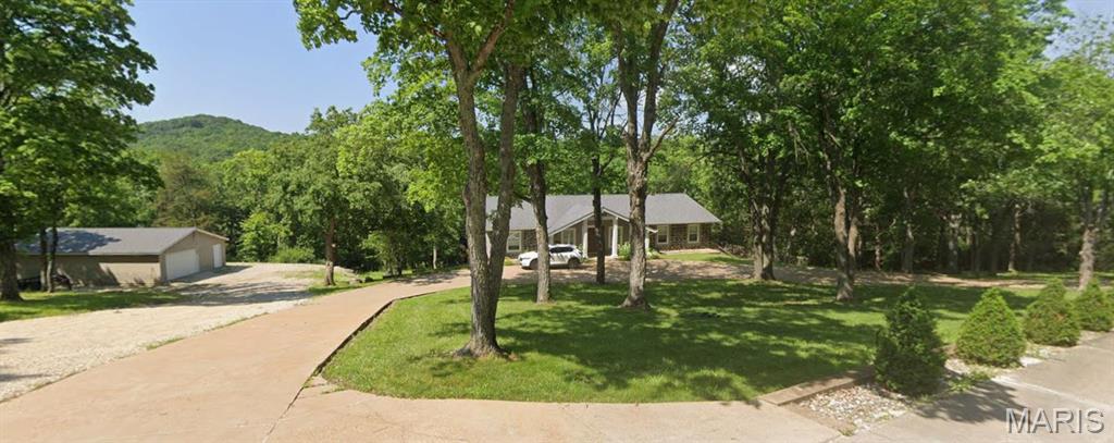 Sequestered among the hills, an immaculate home, with a meticulous attention to detail awaits you... spacious rooms, quiet views, built in book cases & crown moldings, 2 fireplaces plus the composite decking covering the tiered decks that overlook the valley & ridges.  For the auto enthusiast, there is a detached garage COMPLETELY finished.  From the professionally finished epoxy floors to the hvac system & the 220 electric, complete with an EV charger and compressor, this deluxe man cave will be the envy of all you know! Inside, remodeling & upgrades are evident.  With plantation & pocket doors the home flows effortlessly from the entry thru the vaulted living room to the eat in kitchen with a view and then to the vast formal dining room that will fit the entire family. On the lower level, you will find the perfect in-law quarters (or rec room) with a full bath, kitchenette and the 2nd fireplace.  Here you can also walk out to the lower deck and enjoy the view.  This is more than just a house, it's a home.  One that you can move right into (easy with a concrete circle drive) and start enjoying the good life!  Showings start Saturday the 14th.  Please schedule your appointment soon!