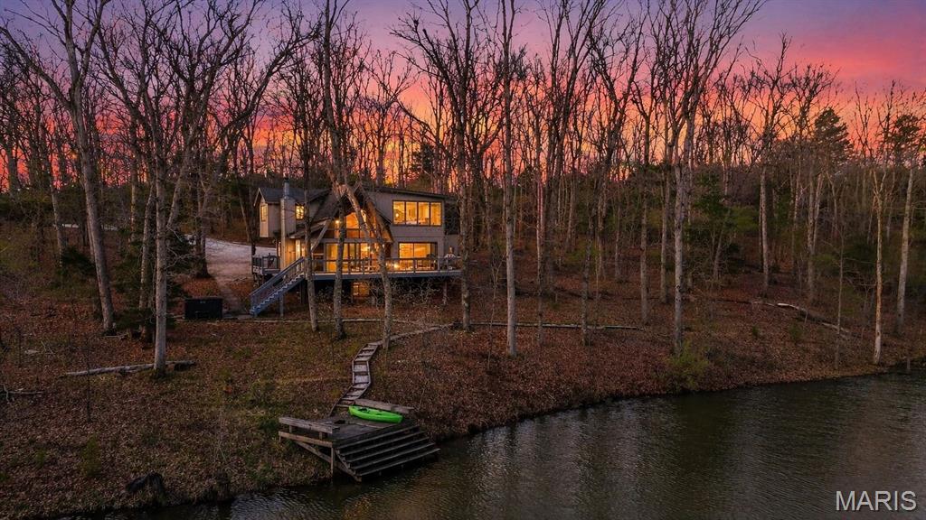 Escape to your own private retreat in the highly sought-after Innsbrook community, where nature, luxury, and resort-style living come together seamlessly. Escape when you want, earn when you don't — this property generated over $67,000 in rental income last year while still leaving room for personal use. Nestled on over 1.3 wooded acres with waterfront access, this stunning A-frame home offers breathtaking views and a true sense of tranquility. Inside, you’ll find an open and inviting floor plan with soaring vaulted ceilings, warm wood-clad interiors, and expansive windows that bring the outdoors in, creating a cozy yet elevated atmosphere. The kitchen features custom cabinetry, stainless steel appliances, and a breakfast bar that flows effortlessly into the dining and great room, perfect for gathering and entertaining. Offering 3 bedrooms and 3 full baths, including a lofted upper level, there is ample space for guests to relax and unwind. Step outside to enjoy your private dock, fire pit area, and multiple outdoor living spaces designed for entertaining or peaceful evenings surrounded by nature. As part of Innsbrook, residents enjoy access to a premier resort community with lakes, beaches, hiking trails, a championship golf course, fitness center, pool, outdoor concerts, and year-round events. Whether you’re looking for a weekend escape or full-time living, this property offers the perfect blend of privacy, recreation, and lifestyle.