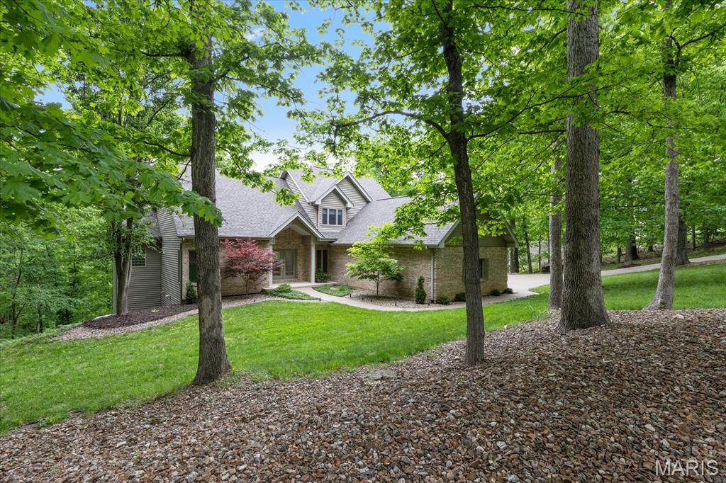 Stunning 1.5-story home on 3+ wooded acres in a quiet, secluded Defiance neighborhood—packed with updates: new carpet & fresh paint throughout (4/26), new quartz countertops & marble backsplash (4/26), and updated baths (4/26). The entry opens to a spacious great room with a floor-to-ceiling brick, wood-burning fireplace and sweeping backyard views. Enjoy a coffered-ceiling dining room plus flexible den. Main-level primary suite features vaulted ceilings, private deck, and spa bath with jetted tub, separate shower, and dual vanities. Kitchen offers newer stainless appliances, custom island, versatile breakfast/wine bar, and walk-in pantry; breakfast area walks out to a large composite deck. Upstairs: loft + two bedrooms with large full bath. Finished walkout lower level includes custom bar, full bath with natural marble shower, cedar closet, and access to an exposed-aggregate patio. Extras: heated/insulated 3-car garage, exposed-aggregate drive/sidewalks, landscaping + sprinklers, impact-resistant roof (7/25), water softener (2023), dual-fuel high-efficiency heat pump, and central vac—minutes to wineries and outdoor fun.