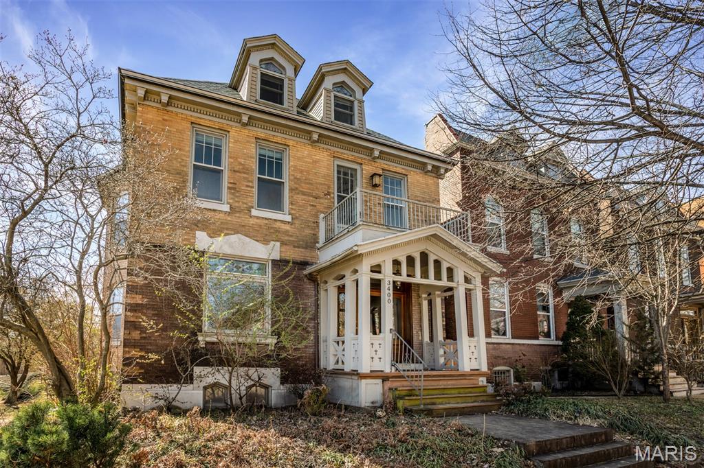 Discover this grand home that absolutely epitomizes St Louis elegance. Standing as an architectural landmark in Tower Grove East, a neighborhood known for striking manses just off the park, this 3300 sq foot, 6 bed, 3.5 bath property hosts the ideal blend of historic details and modern living. You'll immediately recognize this corner beauty from it's distinct brickwork and elegant gingerbread porch that frames the entrance. A massive oak door swings onto blond hardwood and a grand foyer offering the options of heading up the formal stairwell, direct flow toward the kitchen, or a left turn through delicate french doors that introduce a high-ceilinged and sun-filled living room with original stained glass window and white-tiled fireplace. Beyond massive pocket doors admire a dark-wood coffered dining room with a second stately mantle. From here pass into the relaxed rear family room crafted with custom built-ins, and located right off a loaded kitchen that offers exposed brick, solid surface countertops, stainless appliances, and original butler's pantry. The first floor laundry and large powder room are just down a wide hall composed of even more custom shelving. Up the grand stairwell pass another original stained glass window and built-in bench, and find a grand primary suite with separate tub and shower, and walk-in closet. Huge pocket doors offer options of either opening to expand the primary to include a private entertainment space, or closing, separating a stately office. 2 additional bedrooms and the hall bath give kids or guests privacy and elbow room for their own morning rituals. On the third floor yet 2 more sunny bedrooms are carefully tucked into the eaves, and share a third full bath. The semi-finished basement includes a generous rec room with tall ceilings and plenty of storage. Head out back to discover a covered porch, fully fenced yard, and garage to keep those cars you won't be needing in this oh-so-walkable neighborhood that includes the Tick-Tock Tavern, Shaved Duck Smokehouse, the main entrance to one of the cherished parks in the city, and amazing community.  Call your agent to find everything special 3400 Magnolia holds, today!!