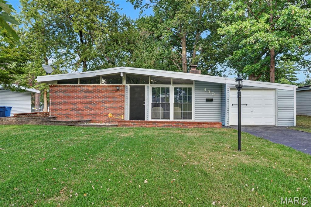 Welcome home to 430 Holiday Hill! This beautifully updated 3-bedroom, 1.5-bath home is filled with natural light and accented by vaulted ceilings that create an open, airy feel. The inviting kitchen features crisp white cabinetry, stainless steel appliances, and a sliding glass door that opens to a private brick patio—perfect for easy outdoor entertaining. The spacious primary bedroom offers the added convenience of a private half bath, while two additional bedrooms, a full bath, and utility/laundry room complete the main living space. Out back, enjoy a level, fenced-in yard with a peaceful tree-lined backdrop. An attached 1-car garage adds everyday convenience. Ideally located near Florissant Valley Park, James Eagan Community Center, shopping, and Highway 270!