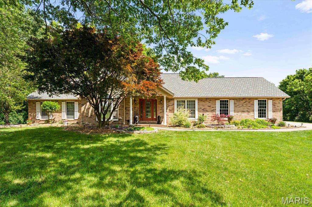 Spacious, private, and surrounded by nature—this exceptional 6-bedroom, 4-bath ranch in the desirable Sugar Creek subdivision offers over 3 wooded acres and a rare combination of luxury, flexibility, and everyday comfort. Tucked away on a quiet cul-de-sac, this property delivers the feel of a private retreat while remaining just minutes from shopping, dining, schools, and convenient access to I-55/I-70 and St. Louis.

Inside, the open-concept floor plan is filled with natural light from oversized windows and skylights, showcasing hardwood flooring, soaring vaulted ceilings, and scenic backyard views. The beautifully updated kitchen is designed for both entertaining and daily living, featuring granite countertops, custom cabinetry, a large center island, stainless steel appliances, a wine refrigerator, and a built-in coffee bar. The inviting hearth room with a double-sided fireplace creates a warm gathering space, while the sunroom provides the perfect place to relax and enjoy the peaceful wooded setting.

The main level includes four bedrooms, highlighted by a spacious primary suite with a walk-in closet, dual sink vanity, soaking tub, and tiled shower.

The finished walk-out lower level dramatically expands the living space with two additional bedrooms, a full bath, family room with fireplace, game area, exercise room, bonus spaces, second laundry area, and abundant storage. Whether you need multi-generational living space, guest quarters, a home office setup, or flexible recreation areas, this layout offers endless possibilities.

Step outside and enjoy your own private backyard oasis featuring mature trees, a pond with fountain, and the peaceful setting that only a large wooded lot can provide. Opportunities like this are hard to find in Edwardsville—a spacious ranch home with acreage, privacy, modern updates, and room to live, work, and entertain all in one property.