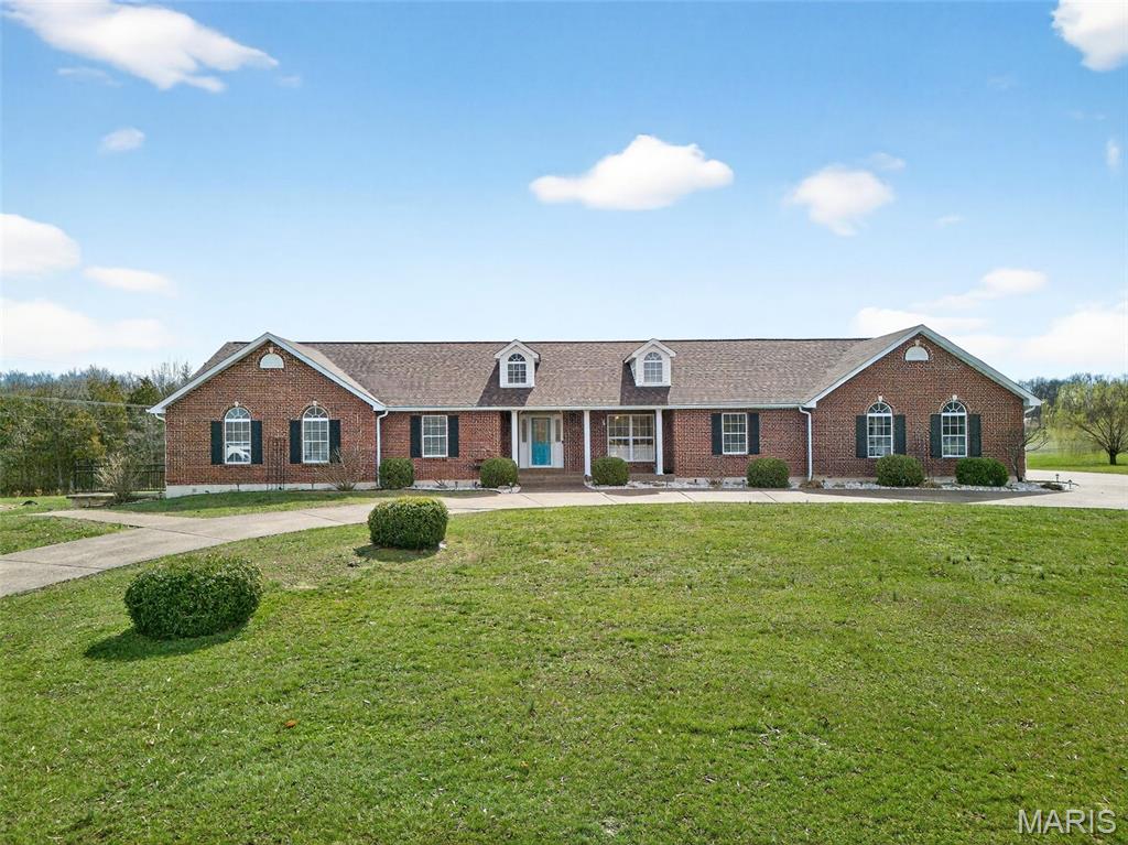 Come See Beautiful Home in Beautiful Subdivision!! Large, beautiful ranch offering a full brick front with dormers, 5 bedrooms, and 3.5 bathrooms with over 2,800 square feet on the main level and additional finished space in the walkout lower level. Located in the very desirable Pinecrest Subdivision featuring paved roads and a 13-acre subdivision lake with subdivision access. The home sits on a beautiful 3.6-acre lot across the street from the lake, offering stunning front views.
The property features an aggregate circle drive, an oversized three car side entry garage, and a very large 36 by 22 tuck under garage in the rear. The huge vaulted great room includes hardwood floors and custom woodwork. The amazing kitchen offers abundant custom cabinetry, a large center island with a smooth top stove and breakfast bar, double oven, quartz countertops, and ceramic tile flooring. There is also a separate dining area.
The main floor laundry room measures 15 by 9 and includes a sink, cabinets, and a coat closet. A large vaulted four season room is located off the back of the home with beautiful views. The spacious primary bedroom features a large walk in closet and a luxury bathroom. Two additional large bedrooms share a Jack and Jill bathroom. The fourth bedroom, located near the four season room, is perfect for an office.
The lower level offers a very large family and game room, a wet bar, a spacious fifth bedroom, and a third full hall bathroom. Walk out to a sprawling partially covered patio with a fire pit area and a sidewalk leading to the front of the home.
Additional updates include a newer heating, ventilation, and air conditioning system, roof, and gutters installed in 2023, as well as a new upgraded septic system in 2022. You will love this home and the subdivision. Schedule your showing today.