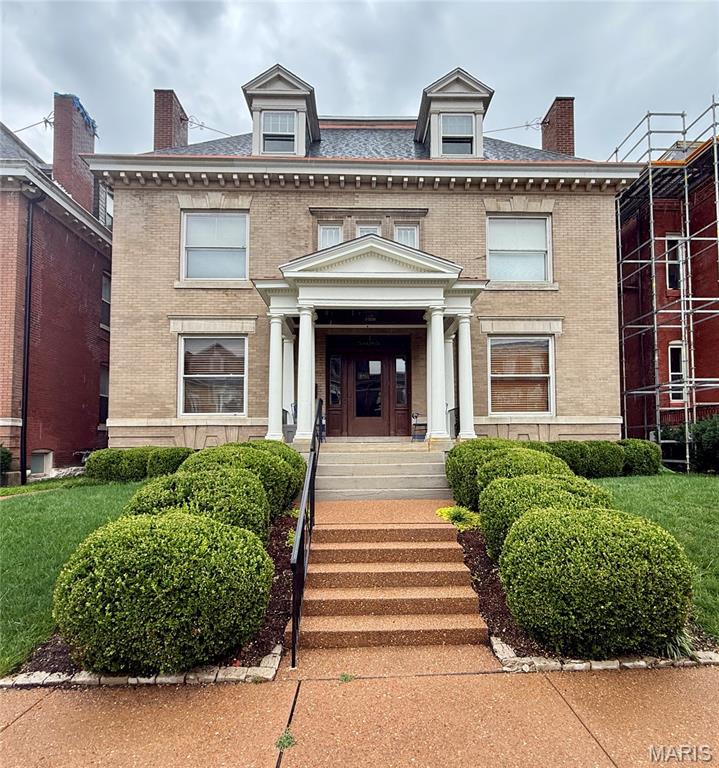Set behind the gates of the prestigious Forest Park Place private enclave, this distinguished Georgian Revival residence, built in 1902, is a remarkable example of St. Louis' architectural heritage. Thoughtfully renovated in 2008 while preserving its timeless character, this exceptional home offers over a century of elegance paired with today's modern comforts. A picturesque, professionally landscaped yard creates a private outdoor retreat featuring a brick walkway, expansive patio, tranquil waterfall, mature plantings, and a detached two-car garage. Recent improvements include a new roof, freshly painted exterior, and new carpeting, providing peace of mind for years to come.
Step through the custom front door into a breathtaking foyer where a statement chandelier, rich hardwood floors, and exquisite millwork set the tone for the home's refined craftsmanship. The grand great room is designed for both elegant entertaining and everyday living, boasting custom built-in bookcases, a fireplace, soaring ceilings, and two stunning chandeliers. The formal dining room showcases its own fireplace and pocket doors, creating an inviting setting for intimate dinners or larger gatherings. The beautifully appointed kitchen blends classic style with exceptional functionality, featuring a center island, granite countertops, custom 42-inch cabinetry, farmhouse sink, Thermador gas range with custom hood and pot filler, double ovens, beverage refrigerator, stainless steel appliances, and an adjoining breakfast room filled with natural light. The second level is anchored by a luxurious primary suite complete with a spacious sitting room, walk-in closet, and an updated spa-inspired bath featuring dual vanities and an oversized walk-in shower. Two additional bedrooms and a beautifully updated hall bath with a whirlpool tub and separate shower complete the level. The third floor provides remarkable flexibility with two additional bedrooms, a private office with built-in cabinetry, a large walk-in closet, a full bath, and an additional office or bonus room—ideal for today's work-from-home lifestyle, guest accommodations, or creative space. Located in one of St. Louis' most coveted private neighborhoods, this extraordinary residence offers an unmatched combination of historic grandeur, modern updates, and an exceptional Central West End location just moments from Forest Park, world-class medical institutions, acclaimed restaurants, and cultural attractions.