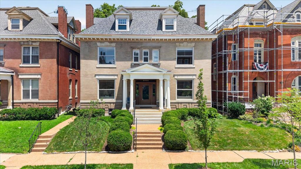 Set behind the gates of the prestigious Forest Park Place private enclave, this distinguished Georgian Revival residence, built in 1902, is a remarkable example of St. Louis' architectural heritage. Thoughtfully renovated in 2008 while preserving its timeless character, this exceptional home offers over a century of elegance paired with today's modern comforts. A picturesque, professionally landscaped yard creates a private outdoor retreat featuring a brick walkway, expansive patio, tranquil waterfall, mature plantings, and a detached two-car garage. Recent improvements include a new roof, freshly painted exterior, and new carpeting, providing peace of mind for years to come.
Step through the custom front door into a breathtaking foyer where a statement chandelier, rich hardwood floors, and exquisite millwork set the tone for the home's refined craftsmanship. The grand great room is designed for both elegant entertaining and everyday living, boasting custom built-in bookcases, a fireplace, soaring ceilings, and two stunning chandeliers. The formal dining room showcases its own fireplace and pocket doors, creating an inviting setting for intimate dinners or larger gatherings. The beautifully appointed kitchen blends classic style with exceptional functionality, featuring a center island, granite countertops, custom 42-inch cabinetry, farmhouse sink, Thermador gas range with custom hood and pot filler, double ovens, beverage refrigerator, stainless steel appliances, and an adjoining breakfast room filled with natural light. The second level is anchored by a luxurious primary suite complete with a spacious sitting room, walk-in closet, and an updated spa-inspired bath featuring dual vanities and an oversized walk-in shower. Two additional bedrooms and a beautifully updated hall bath with a whirlpool tub and separate shower complete the level. The third floor provides remarkable flexibility with two additional bedrooms, a private office with built-in cabinetry, a large walk-in closet, a full bath, and an additional office or bonus room—ideal for today's work-from-home lifestyle, guest accommodations, or creative space. Located in one of St. Louis' most coveted private neighborhoods, this extraordinary residence offers an unmatched combination of historic grandeur, modern updates, and an exceptional Central West End location just moments from Forest Park, world-class medical institutions, acclaimed restaurants, and cultural attractions.