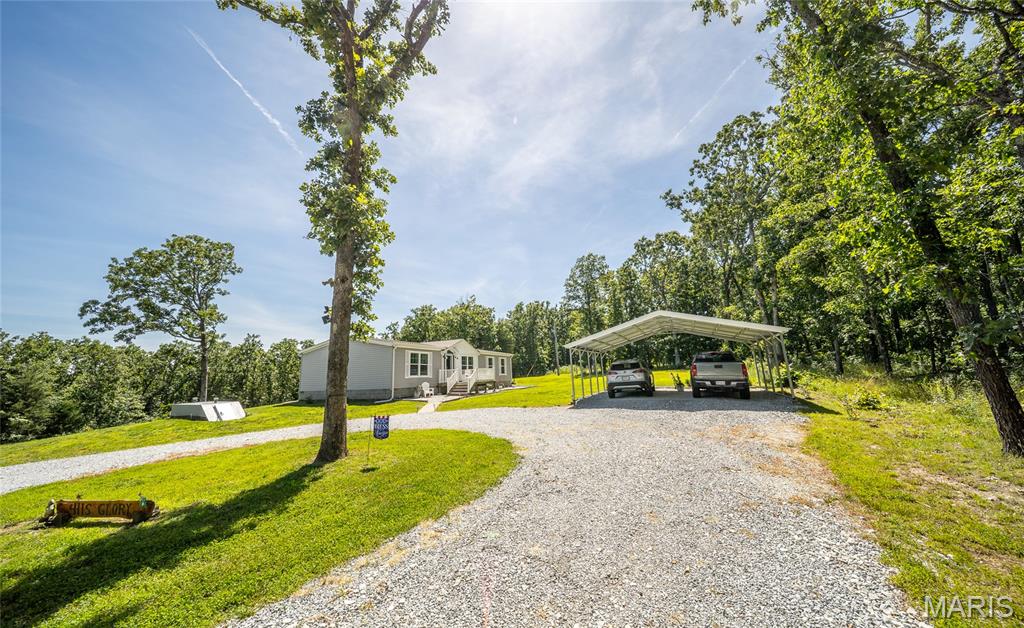 Escape to your own private outdoor paradise with this stunning 73.59-acre property, where peaceful country living meets endless opportunities for recreation, hunting, farming, or simply enjoying nature. Built in 2021, this beautiful 3-bedroom, 2-bath home offers modern comfort surrounded by rolling acreage, scenic trails, and breathtaking views in every direction. Imagine starting your mornings on the spacious front deck with a cup of coffee while watching wildlife roam the property, then ending your evenings on the oversized back deck as the sun sets over your private retreat. Inside, you'll find a thoughtfully designed floor plan with comfortable living spaces and a versatile bonus room that can easily serve as a home office, hobby room, playroom, or guest space to fit your needs. The land has been thoughtfully improved with established trails throughout, multiple food plots, a stocked pond filled with catfish and bluegill, and a dedicated garden area for those seeking a more self-sufficient lifestyle. The property is equally equipped for work and play, featuring a 24x21 carport, a 16x40 outbuilding and 12x15 outbuilding with electricity, an RV pad with electric hookup, and a storm shelter for added peace of mind. Whether you're storing equipment, pursuing hobbies, hosting guests, or managing your own homestead, you'll appreciate the flexibility this property provides. With a new roof already in place and modern construction throughout, this is a rare opportunity to own a turnkey acreage property that offers privacy, functionality, and room to grow. If you've been searching for a place where you can truly disconnect and enjoy the outdoors, this is it. Schedule your private showing today and experience everything this exceptional property has to offer.