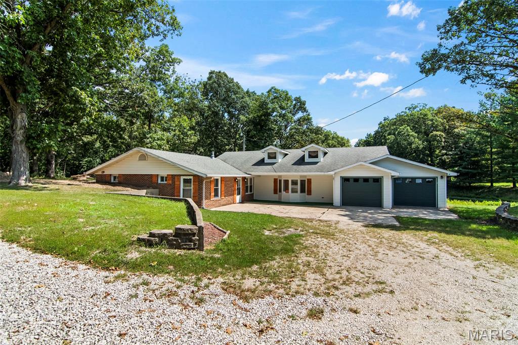 Room to Live, Space to Roam - 2.61 Acres, a Pond & Outbuildings Too! Looking for a little more room to spread out? This spacious 3-bedroom, 2-bath home sits on 2.61 acres with its own pond, mature trees and plenty of space to enjoy the outdoors! Inside, you'll find a surprisingly versatile floor plan with multiple living and gathering spaces. The inviting living room features a fireplace accented by a dramatic stone wall, while the large family room offers vaulted ceilings, abundant natural light and plenty of room for entertaining. The kitchen offers plenty of cabinetry and counter space along with stainless appliances and convenient pass-through openings that keep it connected to the surrounding living and dining areas. A separate dining area provides additional space for meals and gatherings, while the dedicated office/bonus room is ideal for working from home, hobbies or whatever extra space your lifestyle requires. Three bedrooms and two full baths round out the sleeping quarters, and the generously sized laundry room provides additional storage and convenient access to the outdoors. One of the property's standout features is the expansive sunroom, surrounded by windows and overlooking the peaceful grounds - an incredible space for entertaining, relaxing or simply enjoying the changing seasons and views of the property. Outside is where this property really shines. With 2.61 acres, a private pond, mature shade trees and open lawn, there's room to garden, play, entertain or simply enjoy having some breathing room and watching the wildlife. An attached garage provides everyday convenience, while the large detached outbuildings with multiple overhead doors offers valuable additional space for vehicles, a workshop, lawn equipment, recreational toys or storage. With a pond, acreage, multiple living spaces, a huge sunroom, attached garage and substantial outbuilding, this property offers the kind of space and versatility that's hard to find - all in one package!