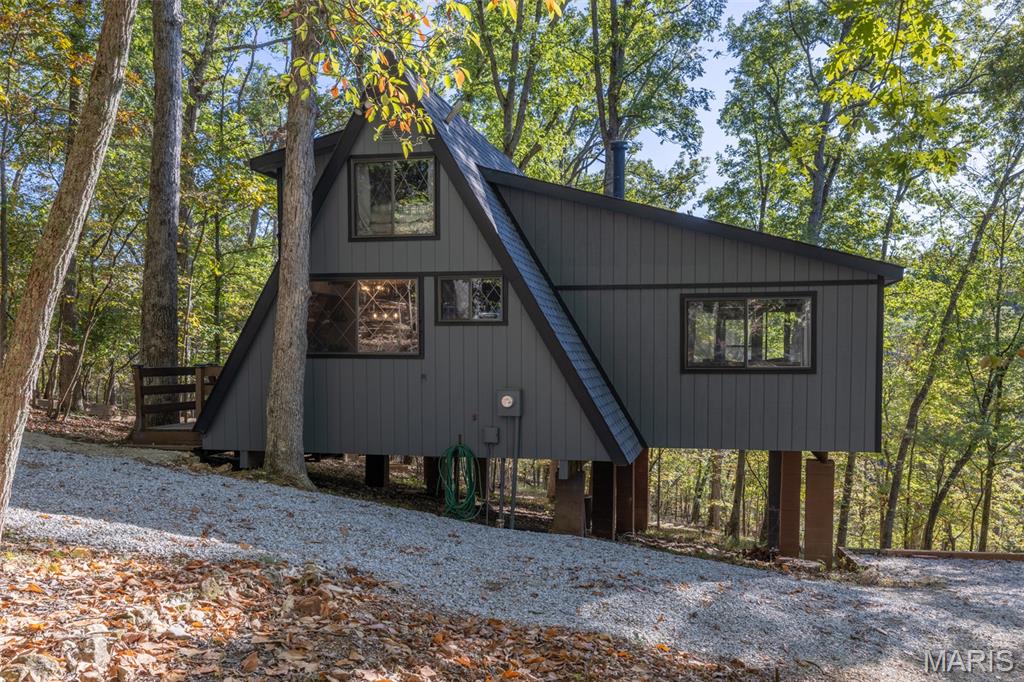Rare opportunity to own a turnkey, income-producing waterfront chalet situated directly on Lake Solitude in the heart of Innsbrook Resort. This charming 1-bedroom, 1-bathroom chalet with loft is approximately 1,200 sq. ft. of thoughtfully updated living space and is currently operating as a successful short-term rental under professional management by Innsbrook Vacations, offering an investor-ready asset with an established booking history and outstanding guest reviews. Step inside the Chalet to find soaring vaulted ceilings and a warm, inviting living area anchored by a wood-burning fireplace. The main level features a private primary bedroom with a queen-sized bed and sliding glass doors opening directly to a screened-in porch, providing scenic views of Lake Solitude. The upper loft accommodates additional guests with three double beds, making this chalet ideal for families and entertaining. The fully equipped kitchen boasts custom cabinetry and stainless steel appliances, perfect for extended stays and family gatherings. This property has been meticulously maintained and significantly upgraded. In 2021, the owners completed a comprehensive renovation package including: new roof, new James Hardie fascia, new kitchen cabinets, new luxury vinyl plank flooring throughout main floor, new water heater, new septic tank, new seawall and landscaping, including a fire pit area, private beach, and walkway from the Chalet to the outdoor features. In 2023, the main water supply line to the chalet was replaced, ensuring long-term structural integrity and peace of mind for the next owner. The private outdoor experience is exceptional. An expansive deck overlooks Lake Solitude, views of dense Missouri hardwoods, and features outdoor furniture and a gas grill. The newly constructed fire pit area and the private beach provide multiple gathering spaces to create memories to last a lifetime. A private dock and beach, with direct lake access, round out a truly complete waterfront package. Currently enrolled with Innsbrook Vacations — the resort's established, professional short-term rental management company — this chalet benefits from a full-service management model including booking, guest communications, housekeeping, and maintenance coordination. Strong guest reviews reflect consistent satisfaction and repeat visitation. The property is move-in ready as a primary residence, second home, or seamless continuation as a short-term rental investment. Owners and guests enjoy full access to Innsbrook's world-class resort amenities including: 150+ acre Lake Aspen, seasonal swimming pool with lazy river, 18-hole golf course, driving range, fitness center, 7 hiking trails, tennis and pickleball courts, basketball courts, outdoor amphitheater, Clubhouse Bar & Grille, children's playground, community beaches, seasonal boat rentals, and the Country Market and Aspen Café. Don't miss this rare combination of waterfront lifestyle, substantial recent capital improvements, and immediate rental income potential in one of Missouri's most beloved resort communities.