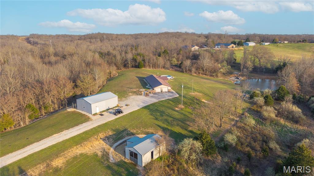 This 35 +/- acre rustic farmstead is a fantastic blend of functional infrastructure and natural beauty in Whitewater, Missouri. Surrounded by working farms, wide-open skies, and local Missouri Conservation Department destinations for fishing and exploring the outdoors, this property offers a peaceful, self-sustaining lifestyle with a private well and premier amenities already in place. The 1,793 square foot earth contact residence is both comfortable and energy efficient. While nestled along a blacktop county road, this home is spacious with a well-insulated floor plan designed for year-round comfort and low utility costs. This 3 bedroom, 2 bathroom home offers both a formal dining room, living room, and a separate family room. Designed for connection, the kitchen features a breakfast bar that opens directly into the family room, creating an inviting space for casual dining or hosting. Take in spectacular Missouri sunsets from the porch overlooking the back field & stocked pond, or enjoy the above-ground pool and deck during the summer months.

This farm is a haven for outdoor enthusiasts & nature lovers. Its diverse landscape includes pastures ready for grazing or hay production, along with two stands of prospective timber creating a prime habitat with plentiful game and wildlife frequently seen across the acreage. The property is uniquely equipped with two water sources, a smaller pond located by the post and beam barn, and a second, well-established, stocked pond complete with a pavilion—the ultimate centerpiece for fishing and quiet afternoons by the water. Take advantage of the trail system on the perimeter and interior of this property to traverse all its offerings.

Just minutes from the driveway are MDC's Lake Girardeau and Block Hole Access; these are perfect for fishermen and outdoor adventurers. This property is fully equipped for craftsmen, hobbyists, or equestrian enthusiasts. The professional-grade outbuildings include: a robust 30'x50' shop with a concrete patio—ideal for equipment storage, a home business, or large-scale projects, and a dedicated 4-to-6 stall barn with tack room. There is also an original post & beam barn, a nostalgic, original farm building that adds timeless character and versatile storage to the property. This is a rare opportunity to own a creative canvas and rustic farmstead on acreage with high-value structures, excellent hunting, and unmatched privacy in a quiet farming community.