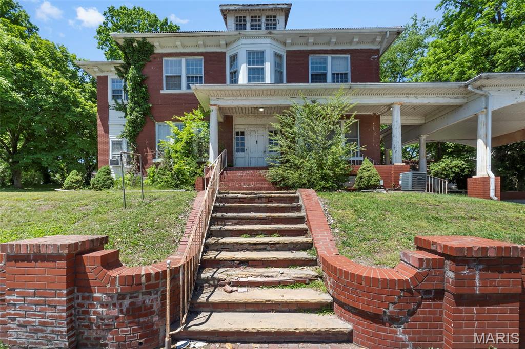Historic character, timeless architecture, and endless potential define this remarkable Neoclassical Revival property near the Southeast Missouri State University campus. Featuring a grand two story portico, striking 13” brick exterior walls, and incredible original details throughout, this property is ready for someone with vision to restore it to its former glory or reimagine it as a unique investment opportunity. Inside, you'll find a dramatic grand staircase, pocket doors, original wood floors, built ins, a butler’s pantry, maid’s quarters, and a massive fireplace that anchors the home with historic charm.
The detached carriage house has already been converted into apartment style living with 6 rooms and 2 bathrooms, adding excellent income potential or flexible use options. With its prime location near campus and unmistakable architectural presence, this is a rare opportunity to own one of the area’s historic treasures with substantial upside potential.