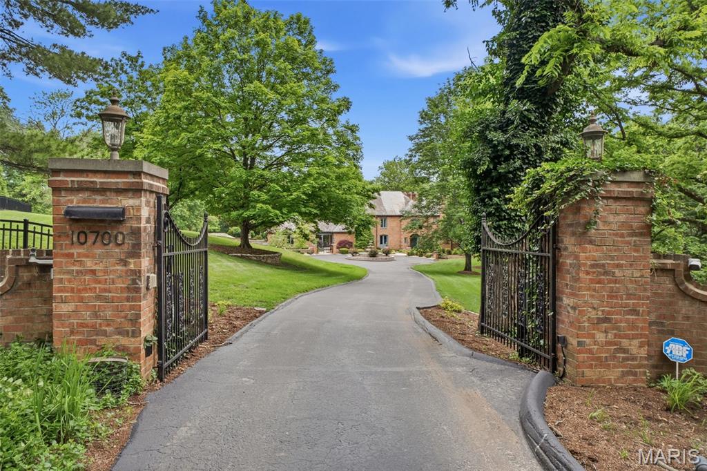 Private, peaceful, and pure bliss at every turn! This enchanting French Country sanctuary offers over 8,700 sq ft of luxurious living space across a beautifully reimagined 4-bed, 3 full and 2 half bath main residence and an updated 2-bed, 3 full bath guest house/pool retreat nestled among the 8+ acres of lush tranquility. The main residence underwent an extensive 2023 renovation transforming the hearth room, dining room, family room, office, laundry room, foyer, both main-level powder rooms, and a breathtaking redesigned chef’s kitchen packed with Sub-Zero & Thermador appliances and dramatic commercial-grade Pella sliders opening to the stunning courtyard patio. A spacious upper-level primary suite serves as a private retreat with a balcony, sitting area, fireplace, expansive dressing room with multiple walk-in closets, sauna, and spa-inspired bath. Secondary bedrooms include custom built-ins and updated finishes, and the fully renovated hall bath is spectacular. Designed for entertaining, the speakeasy-inspired lower level offers a lounge with a stone fireplace, custom bar, wine cellar, full bath, cedar closet, abundant storage, and new flooring. A private resort unfolds as you stroll towards the charming guest house featuring a spa & heated pool with retractable enclosure, app-controlled systems, and Sonos sound throughout. Beautifully updated, the guest house includes 2 full baths & a kitchen on the main, and a 2 bed/1 bath apartment with a full eat-in kitchen upstairs. The manicured grounds are equally captivating with a tiered fountain, koi pond & stone stream bed, stamped concrete patios and walkways, lush professional landscaping, irrigation system, and private gated entrance. Additional highlights include garages for 5 vehicles, updated HVAC and water heaters, smart security system, and extensive system upgrades throughout. A truly one-of-a-kind estate offering extraordinary privacy, resort-inspired living, and timeless French Country elegance—all conveniently located near premier shopping, dining, hospitals, and within the highly sought-after Lindbergh School District. See feature sheet for more details!