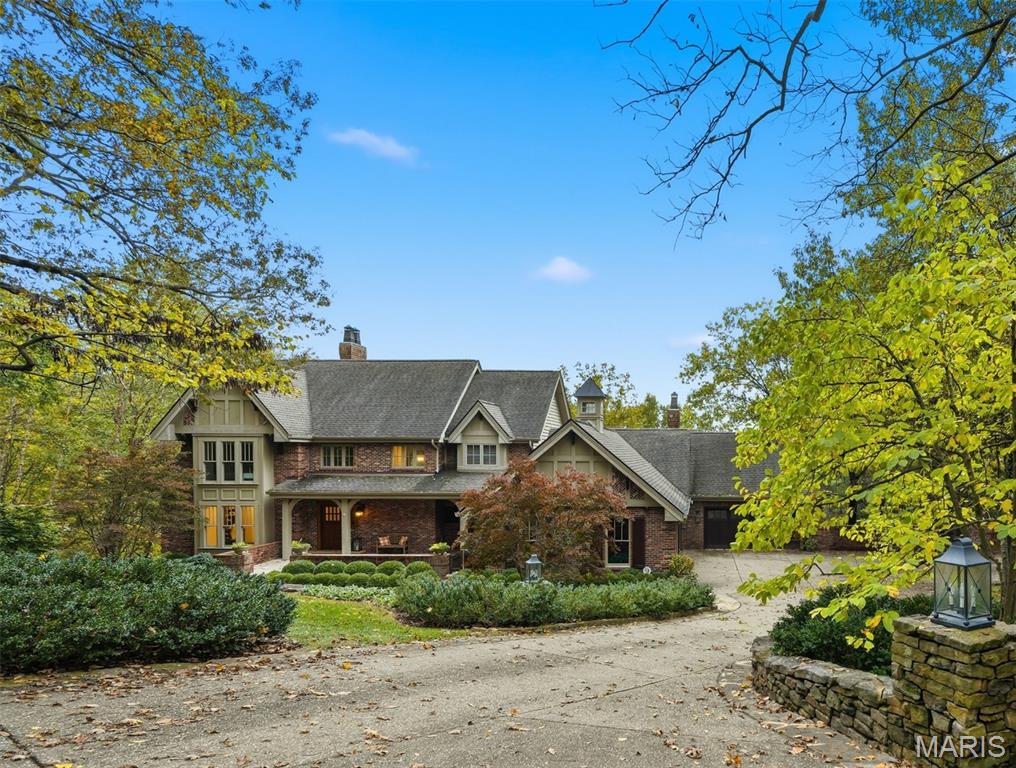 What an extraordinary home.  Nestled on over 4 private acres, this beautiful retreat is one you can enjoy year.  Private inground pool and outstanding views from every window.  This gracious 1.5 story has a two-story great room with rear wall of windows that walks out to an expansive deck overlooking the large private yard and pool area.  An open floor plan with large kitchen in center of home and adjoins the hearth room. Granite counters, custom cabinets, stainless appliances, center island, wood flooring. First floor laundry off kitchen with cabinets and built in sink. First floor master suite with private bath and newly expanded walk in closet. Upstairs there are three generous bedrooms each connecting to a bath.  The lower level is finished with a large rec room and walk behind wet bar, media room, exercise room, wine cellar, hot tub porch and plenty of storage.  There is a covered area at the walk out and a nice level grass yard before the yard gently rolls down into the woods.  Very private, with nature at its best.  Outdoor firepit patio to catch the nightly sunsets. 5 garage spaces plus extra parking at guest parking pad for two.  Large covered front porch.  Impressive front drive leading to home that sits back from the street.  New roof, gutters and skylights installed December 2025.  Truly one of a kind!