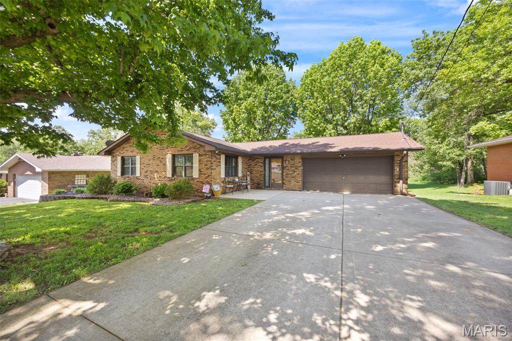 Welcome home to 2103 Golfview Drive, a beautifully maintained Collinsville property that offers fantastic functional space and an exceptional outdoor setup. Upon entering, you are greeted by a distinct, cozy living room that sits comfortably detached from the rest of the main floor, providing a quiet retreat away from the hustle of the rest of the house. Beautiful wood floors flow seamlessly across the entire main level. Down the hall, you will find a bright and lovely kitchen and dining combination. This functional space features a built-in trash compactor and a standout, spacious walk-in pantry that offers ample storage. Two comfortable bedrooms are located on the main floor, including a primary bedroom complete with custom built-ins and a generous walk-in closet. The main floor is serviced by a full bathroom featuring a relaxing jetted tub.

The finished, walk-out lower level significantly expands your living space and offers great flexibility. Here, you will find a quiet bonus room equipped with a closet that makes for the perfect home office, hobby room, or private gym. A second full bathroom in the basement adds wonderful convenience for guests or daily routines.

The outdoor amenities are an absolute showstopper. A large deck spans the entire length of the back of the house, offering effortless indoor-outdoor flow with three convenient access points from the garage, the kitchen, and the secondary main-floor bedroom. Down below, the walk-out basement leads to a lovely, shaded patio seating area nestled under the deck, providing a peaceful retreat overlooking the backyard. For additional storage, a large shed sits in the deep yard, keeping your garage completely clutter-free. Combining smart storage, flexible living space, and an unbeatable backyard setup, this home is completely move-in ready.