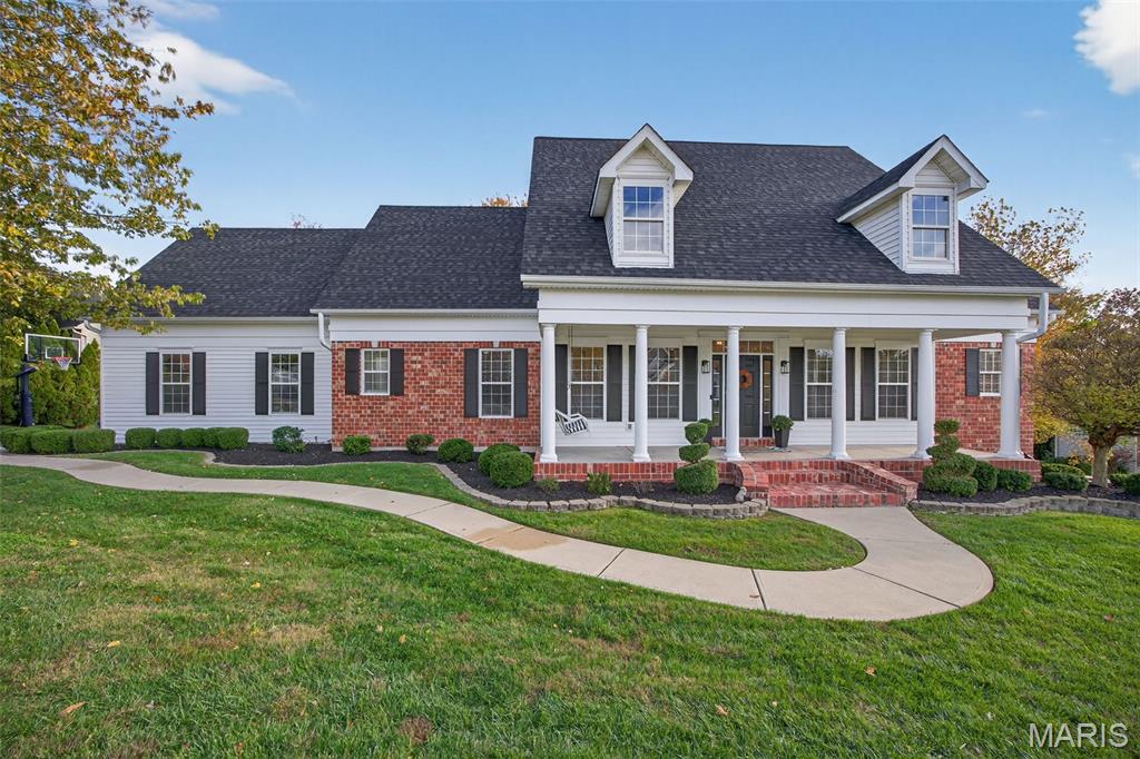 This custom-built Cape Cod–inspired residence offers over 4,200 sq ft of refined living space across 1.5 stories, seamlessly blending timeless architecture with modern luxury.

A grand foyer welcomes you into a thoughtfully designed interior, flanked by a light-filled study with built-ins and a formal dining room enhanced by board-and-batten paneling and crown molding. The elegant great room features a wall of windows, recessed lighting, and signature custom archways, creating a bright yet sophisticated gathering space.

The main level has been beautifully updated with newly refinished hardwood floors, 5” baseboards, designer lighting, and sleek black hardware, delivering a crisp, contemporary feel throughout.

At the heart of the home, the gourmet kitchen impresses with 42” soft-close cabinetry, under-cabinet lighting, a 10’ quartz island, double-oven gas range, coffee bar with beverage cooler, and a spacious walk-in pantry—perfect for both everyday living and entertaining. Just beyond, the inviting hearth room is filled with natural light from dual French doors with transoms and anchored by a charming wood-burning fireplace.

Designed for year-round enjoyment, the screened 3-season room features a stunning stone wood-burning fireplace and overlooks the resort-style backyard.

A standout feature of this home is its rare main-level layout, offering two private bedroom suites. The luxurious primary suite includes adult-height vanities with Moen fixtures, a soaking tub, and a walk-in shower, while the second suite provides a private full bath and walk-in closet—ideal for guests or multigenerational living. A main-floor laundry and powder room complete the level.

Upstairs, a striking iron spindle staircase leads to two spacious bedrooms with new carpeting and an updated full bath featuring a walk-in shower.

The finished walkout lower level expands your living space with a large recreation room with gas fireplace, a fifth bedroom with oversized walk-in closet, full bath, and a flex room perfect for a sixth bedroom, gym, or media space.

Step outside to your own private retreat—a resort-style backyard featuring a heated saltwater pool and spa, fully fenced yard, and a serene 0.6-acre lot backing to woods, offering exceptional privacy.

Additional highlights include a side-entry 3-car garage and major system updates such as new dual-zone HVAC, new hot water heater, and a new architectural shingle roof—providing peace of mind and turnkey living.