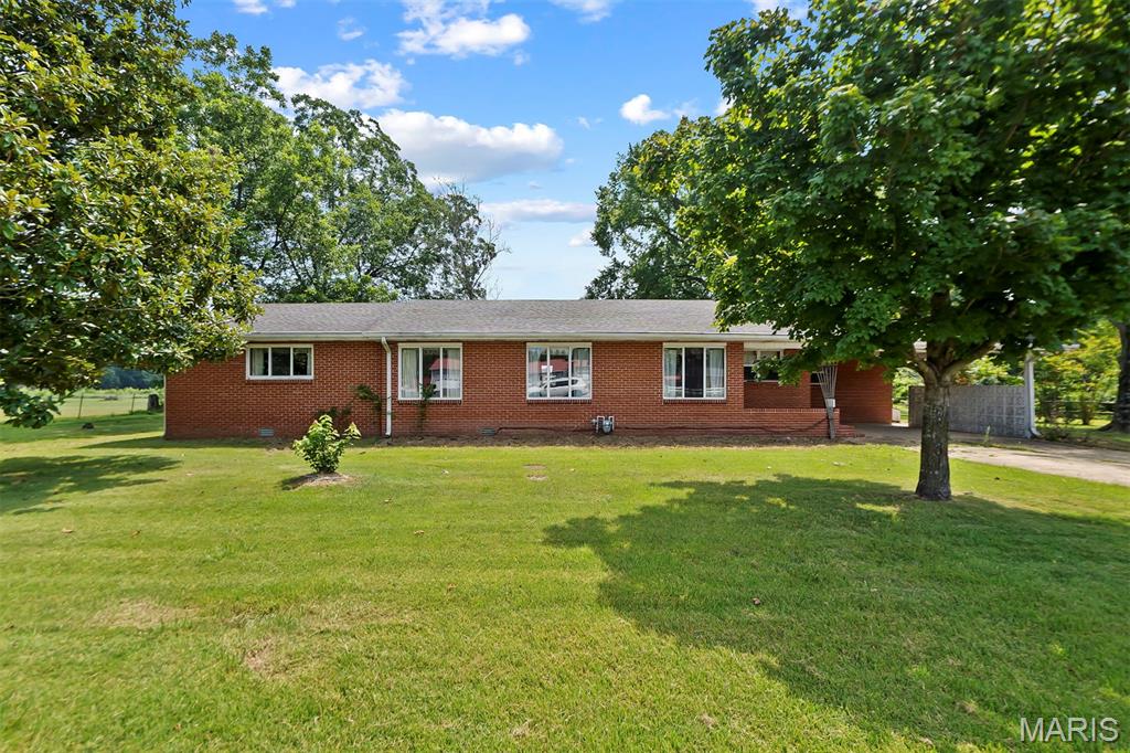 PRICE DROP - here's your chance! Exceptional country living! Nestled on 4.7 +/- acres with a detached, oversized three car garage & a barn - this beautiful 3-bedroom, 2-bath brick ranch home offers the perfect blend of rustic charm & modern comfort, all on one level w/ over 1,800 sqft of living space. Covered carport parking! Step inside and you'll be wowed by the open layout, brick fireplace and great hardwood flooring. Large living room connecting the front dining room and kitchen. Functional kitchen layout featuring ample amount cabinets and gas range. Big main floor laundry room with a sink and lots of cabinets - great additional storage space. You'll love the large screened-in back porch - perfect for cozy evenings outside, hangouts or BBQs! Primary main floor bedroom feat. private ensuite bathroom w/ a large walk-in closet. Two bedrooms with big walk-in closets and a full bath round up the interior of this home. This property is perfect for the perfect for homesteaders or gardening enthusiasts! Partially fenced backyard, lots of areas for gardening, pets+++ The 30x36 three car garage with work bench area is perfect for your equipment, cars, mowers & tools. Additional barn with chicken coop area has great potential for a mini-farm and more! Located close to conservation areas, Black River, Lake Wappapello - easy access to some of the best float trips, boating, fishing, hiking, riding trails and other activities this region has to offer+++ This could be your next HOME or would also make an awesome weekend getaway for you & your family (or use as an AirBNB/ Vrbo)! Great private, country feel with the amount of acreage while still located close to town with shopping, restaurants, schools, hospitals and more. CALL NOW
