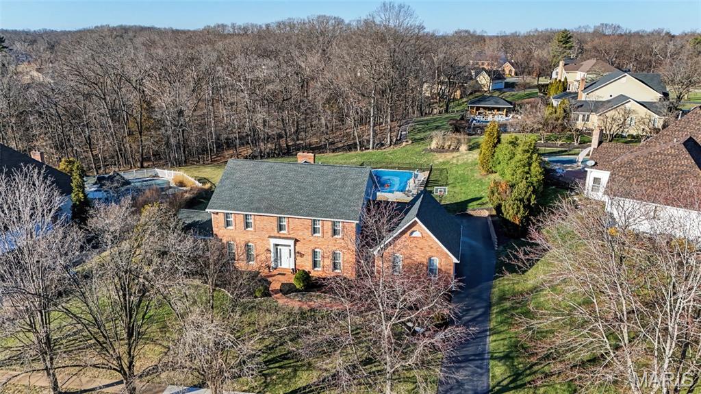 Welcome to this stunning brick 2-story residence in the sought-after Wilson Farm Estates neighborhood, located within the highly regarded Rockwood School District. Blending timeless architecture with elevated comfort, this beautiful home offers an exceptional lifestyle with refined living spaces and upscale features throughout. Inside, hardwood floors extend across the main living areas, creating warmth and elegance from the moment you step through the door. The thoughtfully designed floor plan offers four spacious bedrooms and four and a half bathrooms, providing plenty of room for everyday living, guests, and entertaining. Throughout the home, three fireplaces add charm and a cozy ambiance to multiple gathering spaces. The home is designed to bring people together while still offering peaceful retreats. A bright and inviting three-season room provides the perfect setting for morning coffee, quiet evenings, or enjoying views of the back and side yard while staying comfortably indoors. The finished lower level expands the home’s versatility, offering the ideal space for a recreation room, media lounge, fitness area, or additional entertaining space. Outdoors, the property transforms into a private retreat. The beautifully maintained backyard features a private in-ground pool, creating a resort-style atmosphere perfect for relaxing weekends, summer gatherings, or evening swims. Surrounded by mature landscaping, the setting provides both beauty and privacy. With classic brick construction, spacious living areas, and luxury amenities inside and out, this exceptional property offers the perfect blend of sophistication, comfort, and everyday livability in one of the area’s most desirable communities.