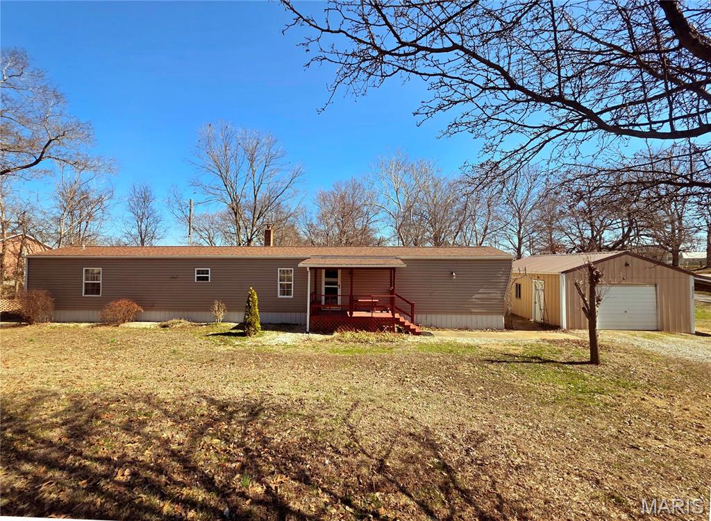 Best of both worlds- Close to town but privately located in county! Modern 3 bedroom, 2 full bath manufactured home, included an enclosed back porch for more livable space and with detached garage/workshop and carport. Well maintained. A/C unit & roof only 3 years old. Living room has electric fireplace. Kitchen appliances, washer & dryer stay. Updated back deck to take in country views. Also has a storm cellar that has a sump pit and wood stove that heats whole home. Nicely manicured and landscaped. Situated on just a little under an acre. Exceptional value- call today!