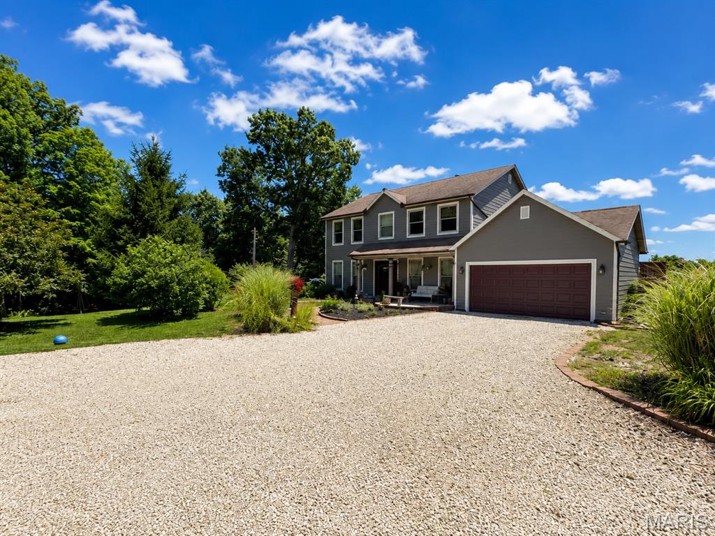 Nestled among mature trees with one of the best views in all of Warren County. This spacious 2-story home offers 4 bedrooms, 3 full baths, a dedicated office, and a finished walkout lower level. The main level features a large family room with fireplace insert, separate dining room, main floor laundry, and an eat-in kitchen with custom cabinetry, breakfast bar, pantry, and sliding door access to the multi-level deck. Upstairs, the primary suite includes a walk-in closet and private bath with double vanity, separate shower, and jetted tub, along with three additional bedrooms.

The finished walkout lower level provides exceptional flexibility with a large recreation room, bonus room, full bath, and dedicated canning room. Enjoy outdoor living from the covered front porch, beautifully landscaped grounds, multi-level deck, and above-ground pool, all surrounded by mature trees and peaceful wooded views.

Car enthusiasts, hobbyists, and small business owners will appreciate the attached 2-car garage, camper carport, and the impressive 30' x 72' four-bay outbuilding featuring approximately 48 feet of finished, heated space with electric and a 2-post lift. Additional updates include a new well pump in 2025, new hardie board siding, new windows, newer water heater, owned 500-gallon propane tank, central vacuum system, and quality 4-panel wood doors throughout. Built in 1989, this property offers the space, functionality, and versatility that are increasingly difficult to find.