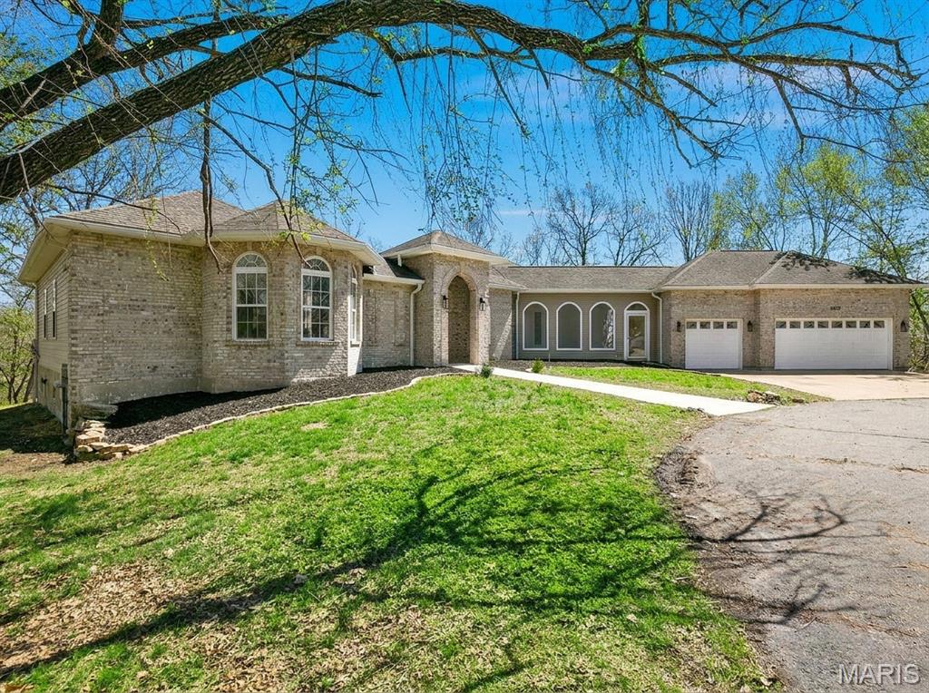 Arriving at this sprawling ranch in Fischer Pointe Estates feels like stepping into your own private retreat. Set on over five wooded acres, the property offers a rare sense of quiet and seclusion while keeping daily life completely connected. Inside, the home has been thoughtfully reimagined from top to bottom, creating a space where a growing family can spread out and settle in immediately.

The main living spaces are anchored by a custom-built entertainment center and a warm gas fireplace, setting the tone for relaxed evenings. From there, the layout flows naturally into a completely overhauled kitchen designed for both quiet mornings and heavy hosting. With expansive new countertops, crisp cabinetry, brand-new appliances, and twin wine fridges, it is a room built for gathering. Natural light pours in through updated windows, highlighting the fresh flooring that runs seamlessly throughout the main level.

The living space expands significantly in the finished walk-out lower level, which flexes easily to fit your lifestyle. A dedicated theatre room with newly cased windows and custom handrails provides the ultimate setting for movie nights, while the surrounding square footage leaves plenty of room for a home office, play area, or guest quarters. Outside, the transition to nature is effortless. Whether you are taking in the wooded views from the freshly painted porches or hosting a summer barbecue on the back paver patio, the grounds offer endless room to breathe, play, and make the space entirely your own.