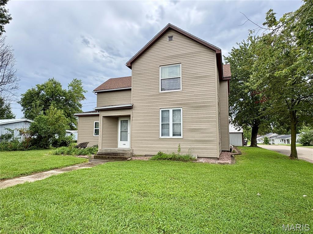 Built around 1900, this spacious two-story home offers an impressive 2,676 square feet of living area with plenty of room to spread out and make it your own. The main level features three bedrooms, two full baths, a den, office, and convenient main-level laundry. A sunken living room with an electric fireplace provides a cozy gathering space, while the generously sized kitchen offers abundant oak cabinetry, plenty of counter space, and a large center island with a concrete countertop and seating for the whole crew. Upstairs, you'll find even more room with an additional bedroom, bathroom, family room, and a large den—providing flexible spaces that can be adapted to suit a variety of needs. With numerous rooms and a unique floor plan developed over the home's long history, there are plenty of possibilities for a buyer with some creativity and a vision for making the space their own. Outside, newer siding adds to the home's appeal, and the 0.43-acre corner lot provides plenty of room to enjoy. An exterior-access cellar offers additional storage, while a two-car detached garage with an attached one-car carport and an additional covered parking space provides an abundance of sheltered parking. A covered patio along the back of the garage creates a great spot for outdoor relaxation. This home may be ready for some cosmetic updates, but with its generous square footage, multiple living areas, four bedrooms, three baths, and ample parking, it offers a lot of space and potential for the buyer looking for a home they can truly make their own.