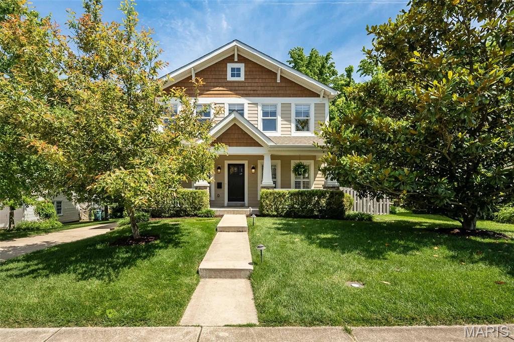 Enjoy the perfect blend of timeless Craftsman charm and newer construction convenience in this stunning upscale home just moments from the heart of downtown Kirkwood. Offering incredible walkability to restaurants, boutiques, parks, the farmers market, and everything downtown Kirkwood has to offer, this beautifully designed residence combines thoughtful craftsmanship, generous living spaces, and an exceptional location.

An inviting front porch welcomes you into a spacious entry where gleaming hardwood floors, rich millwork, plantation shutters, and beautiful architectural details immediately showcase the quality and care found throughout. A spacious dining room just off the foyer provides an elegant space for entertaining or everyday gatherings.

Designed for modern living, the impressive open floor plan seamlessly connects the gourmet kitchen, breakfast room, and family room, creating the true heart of the home. The kitchen features custom glazed maple cabinetry, stainless steel appliances, granite countertops, abundant prep space, and a large center island perfect for gathering with family and friends. Anchoring the main living area is a stunning floor-to-ceiling stone fireplace and a dramatic wall of windows overlooking the private backyard and expansive two-tier deck, all complemented by an oversized detached two-car garage.

Quality details continue throughout with Anderson windows, extensive woodwork, and thoughtfully designed spaces that balance beauty with functionality. An oversized main floor laundry room with cubbies and additional storage makes everyday living effortless.

Upstairs, the spacious primary suite is a luxurious retreat entered through double doors and featuring a large walk-in closet and gorgeous bath complete with a soaking tub and separate shower. Unlike many homes, the secondary bedrooms are impressively sized, offering substantial closet space and room to comfortably grow, work, or relax. A hall bath with double vanities easily serves the additional bedrooms.

The finished lower level offers incredible flexibility with an expansive recreation and family room complete with a kitchenette area—perfect for entertaining, movie nights, guests, or multi-generational living. With an egress window and full bath, this space could easily serve as a fifth bedroom suite, while the unfinished area provides abundant storage or room for a spectacular home gym.

Combining upscale finishes, spacious design, newer-build convenience, and one of Kirkwood’s most walkable locations, this exceptional home truly delivers the lifestyle buyers are searching for.