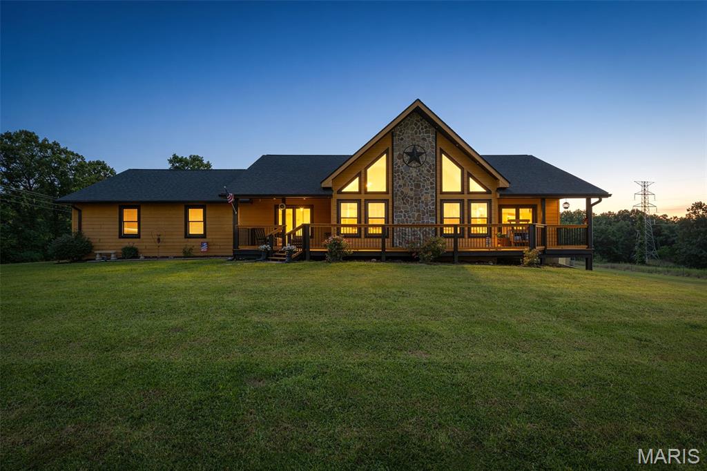 Back on the market, NO FAULT OF SELLER. Welcome to your own piece of paradise! This secluded 31 acre property is nestled just far enough out of town and yet close enough to still have all the conveniences within minutes. The rustic charm of this 4-bedroom, 2-bath, modern ranch style home is thoughtfully designed with maintenance-free fiber cement siding. The main floor great room with its vaulted tongue and groove pine walls and ceiling welcome you inside this comfortable home. The kitchen/dining room combo is just off of the great room with custom cabinetry, ceramic flooring and built-in appliances including a large refrigerator/freezer combo. The under-cabinet lighting is motion sensing and there is ample countertop space with a center island sink/bar area. The main floor laundry/mud room leads you from the kitchen to the oversized two-car garage for easy access to bring in your groceries. The split-floor bedroom design has 2 equal sized bedrooms for the children or guests on one side of the great room with a nice bathroom located between them and the primary suite is located on the other side. Both bathrooms include tub/shower units and ceramic tile floors and all of the bedrooms have ceiling fans for added comfort. The primary bedroom has a large walk-in closet as well. Up a flight of rustic cedar stairs with railing cut from trees on the property is the loft room where you can enjoy a good book or just a little me time. Down to the basement where there is still plenty of opportunity to design the additional space to meet your dreams you will find a fourth bedroom with built-in bunk beds and the beginnings of another bathroom with the shower stall already installed. Also, there is a full concrete safe room with a steel door for storage of valuables or use as a storm shelter. The walkout basement makes for easy access from the yard where you will find an outdoor wood burning furnace that heats the home and water as well.  The property is fenced and cross fenced and has been surveyed and it has about equal amounts of pasture and woods. There is one runout shed located in the front pasture for your animals to shelter in, a separate pipe fenced calf pen and there are two small ponds on the property. The covered deck in the back is just out of the dining area and makes for a great place to grill those steaks or just sit and enjoy a quiet moment. Out front you have two covered porches to choose from as you sit and look out over the pastures and the rolling wooded hillsides that are all yours. There are too many features to cover that make this home the special place that it is so you will just have to come take a look for yourself. So, what are you waiting for?