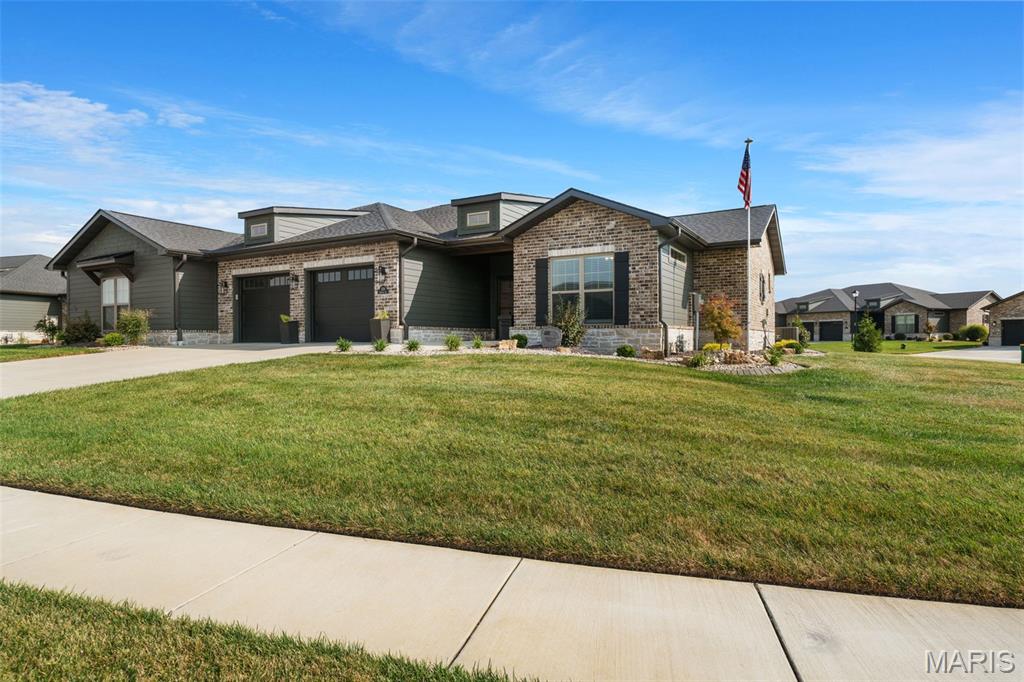 Elegance, ease and exceptional craftsmanship come together beautifully at 1126 Lakeland. Built by State Construction with an unmistakable attention to quality, this impressive villa was designed around a simpler way of living—offering true zero-entry access, refined finishes, generous living spaces and the kind of low-maintenance lifestyle that gives you more time to simply enjoy home.

The upgraded exterior and polished curb appeal offer a fitting introduction to a home where thoughtful design continues throughout. Inside, luxury vinyl plank flooring carries through the main living spaces, complemented by beautiful decorative trim, upgraded lighting and a striking beamed coffered ceiling. At the heart of the living area, a stone gas fireplace adds warmth and character, while generous dining space and sliding patio doors create an easy connection to the outdoors.

The kitchen is polished without feeling pretentious, featuring quartz countertops, a generous center island, touch faucet, black stainless KitchenAid appliances, pendant lighting, ceramic tile backsplash and custom cabinetry finished with crown molding. Just beyond, a separate walk-in pantry takes everyday convenience to another level with matching custom cabinetry, a dedicated coffee bar and wine refrigerator.

Outdoor living feels equally effortless. The screened stamped-concrete patio includes a ceiling fan and electrical connections for a future outdoor TV, while the stamped concrete continues into an additional open patio with plenty of room for grilling, a firepit, hot tub or simply a quiet place to unwind.

The main-floor primary suite feels like a retreat of its own, complete with a beautiful transom window, extended double vanity, impressive walk-in closet with built-ins and a curbless tiled shower with built-in seating and dual shower heads. A second main-level bedroom offers its own private en-suite bath and walk-in closet, creating exceptional comfort and privacy for guests.

Even the practical spaces have been thoughtfully finished. The main-floor laundry includes matching cabinetry, ceramic tile, motion-activated lighting and a washer and dryer with pedestals that remain. The garage continues the zero-entry design and features epoxy flooring, built-in shelving and camera-equipped garage door openers.

A wide, thoughtfully designed staircase leads to the finished lower level, where you'll find another expansive living and entertainment area, full bath, bedroom with egress window and an attractive stone-look surround, generous walk-in closet and a versatile bonus space ready to become whatever life calls for next. Beyond the finished area is an extraordinary amount of unfinished storage, along with CAT5 wiring and a water softener that remains with the home.

Additional conveniences include a Honeywell security system with sensors at exterior doors and windows, wired internet infrastructure and abundant storage throughout.

Best of all, the lifestyle extends beyond the walls. The HOA handles lawn maintenance and snow removal, while the community pergola and gathering space offer an inviting place to connect when you want to—or simply enjoy the peace, privacy and simplicity of having less to maintain.

Beautifully built, impeccably cared for and intentionally designed, 1126 Lakeland offers something increasingly difficult to find: a home that feels luxurious today while making everyday life remarkably easy.