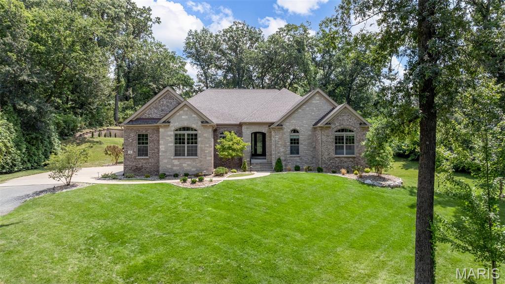 Walk-out Custom Ranch on 1.5 private acres in Ladue, built to a standard that appeals on every level. Four-sided brick and stone. Ten-foot Superior Walls foundation pour. Eleven-foot ceilings on the main floor, 10-foot ceilings in Lower Level. Four-car side-entry garage with 12-foot ceilings, ready for car lifts. Freshly painted throughout, hand-scraped wood floors, and 900+ square feet of brand-new stamped concrete patio out back. Professionally regraded rear yard, transformed a sloped lot into a level, useable lawn, retained by handsome block walls and framed by all-new professional landscaping! Pool-ready lot or just room to spread out in your completely private backyard!  Enjoy the private hot tub and fire pit area, too. Full yard irrigation system. 
Inside, the main floor flows with intention. Open and spacious yet classic and warm. Just off the entry foyer, you'll be greeted by the formal dining room with a coffered ceiling and hand-applied gold paint inlay by artist Susan Greene. A spacious kitchen anchored by a floor-to-ceiling stacked stone arch, huge center island, double ovens, warming drawers, 5-burner gas cooktop, walk-in pantry, and a dedicated Coffee Cafe off the side porch entry. Enjoy the sunlit hearth room with a triple-pane slider to the patio. Stunning primary suite occupying its own private wing, with newly installed wood floors, a gas fireplace wall that makes a real statement, an expansive bay window, an oversized shower with body sprayers, and two custom walk-in closets, including a boutique glam closet with its own island and chandelier.
The lower level earns its own introduction. A full-service custom bar, billiard room with marble fireplace wall, mirrored gym, family media room, and a speakeasy with golf simulator. Two large en-suite bedrooms with egress windows and walk-in closets, plus a spa-style bath with an oversized steam shower, heated towel rack, and second washer/dryer hookups. Generous ceiling height throughout makes every room feel like a destination, not an afterthought.
Gazebo-covered spa just steps outside the lower-level walkout. Control 4 audio throughout. New Space custom closets in most closets. Just a short walk to MICDS.