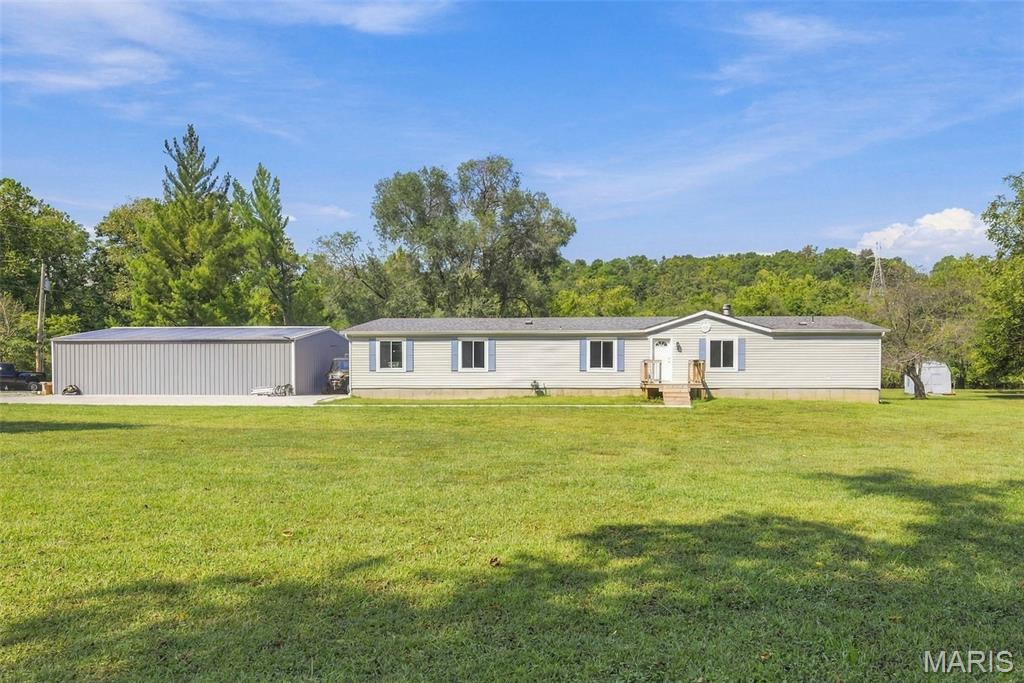 Discover space, privacy, and peaceful country living on approximately 5.78 level acres, this five-bedroom, three-bath home is permanently affixed over a poured-concrete crawl space. Recent improvements include upgraded 400-amp electrical service, updated lighting, a new exterior door, bathroom improvements, and updates throughout several additional rooms. The 24-by-40-foot detached garage features a concrete floor and new 100-amp electrical service. The property extends into a park-like setting with creek access, offering plenty of space to enjoy the outdoors. Schedule your showing to see everything this spacious property has to offer.