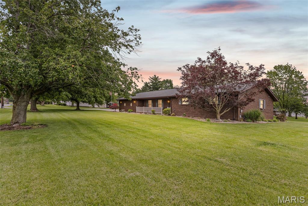 This impressive, all-brick home on a spacious corner lot near West Lake Golf Course perfectly blends quality construction with premium amenities for $399,900. Boasting an expansive open floor plan, the main level offers over 2,400 square feet of living space featuring three bedrooms, three bathrooms, and a chef-ready kitchen complete with granite countertops and included appliances. Downstairs, the full, dry basement provides over 1,000 square feet of additional living area alongside a massive amount of storage space. Designed for ultimate comfort and efficiency, the home is equipped with central vacuum,  zoned heating and cooling, two water heaters, a water softener, and a massive, oversized three-car garage featuring two insulated doors with openers. The exterior is equally impressive, showcasing a beautiful yard, a maintenance-free front porch, and a stunning stamped concrete back patio perfect for entertaining. Contact your favorite agent today to schedule your private showing of this exceptional property!