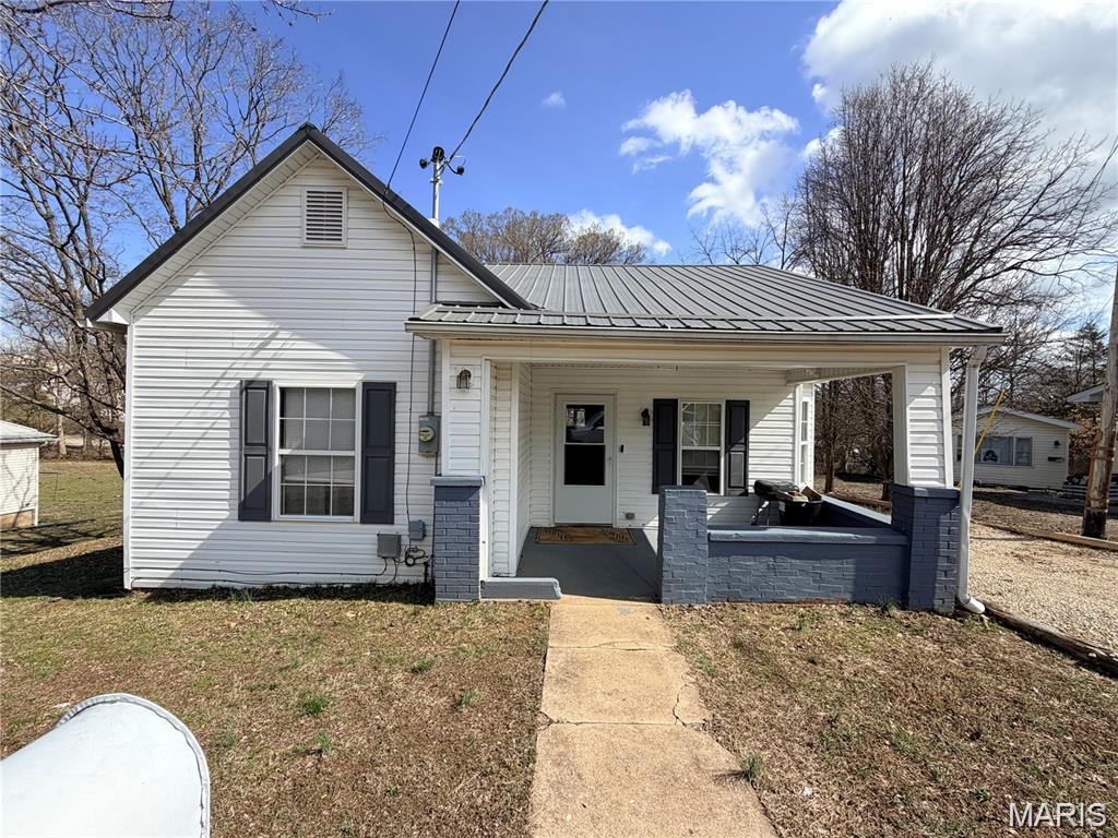 Charming 2-bedroom, 1-bath home featuring a welcoming covered front porch, low-maintenance vinyl siding, and a durable metal roof. Step inside to a spacious kitchen and dining room combo with beautiful original hardwood floors that add warmth and character. This home offers comfortable living with classic charm and plenty of potential to make it your own.