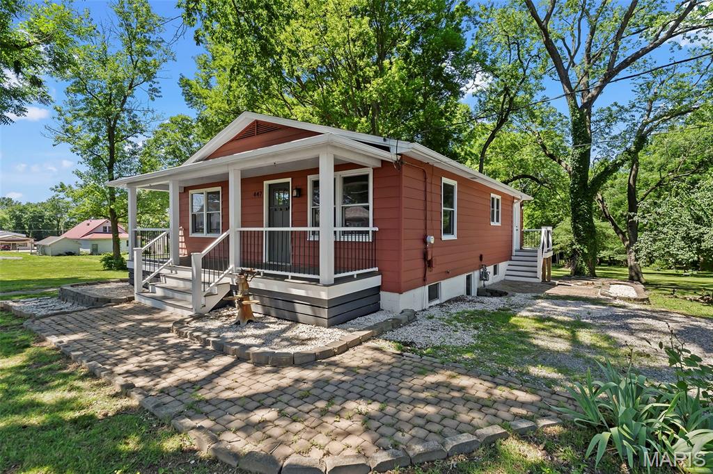 Enjoy peaceful mornings with a cup of coffee on the inviting front porch and unwind in the evenings on the back patio overlooking a mostly private backyard shaded by beautiful mature trees. Situated on a generous 0.4-acre lot, this property offers great outdoor space. Inside, the upper level features two  bedrooms and a full bathroom, while the lower level offers a private primary suite complete with a walk-in closet and en suite bath. Enjoy cozy moments by the gas fireplace in the family room. You will notice updated finishes and light fixtures. The large window off the back of the kitchen allows a wonderful view of the backyard. Located in a well-maintained neighborhood, enjoy the convenient location with quick access to shopping, dining, healthcare, and recreation.
